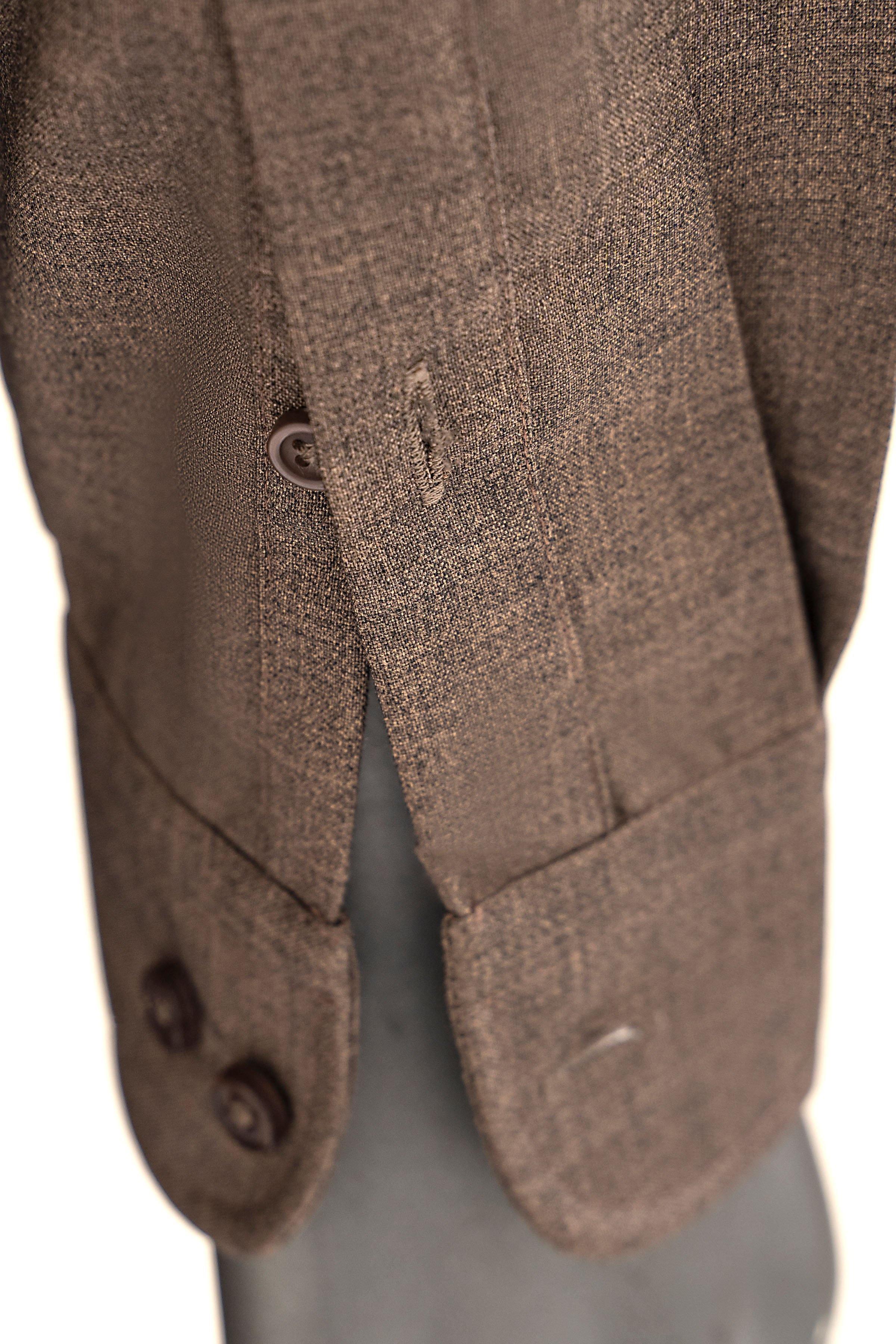 Brown cuff and button detail on kameez sleeve, textured woven fabric
