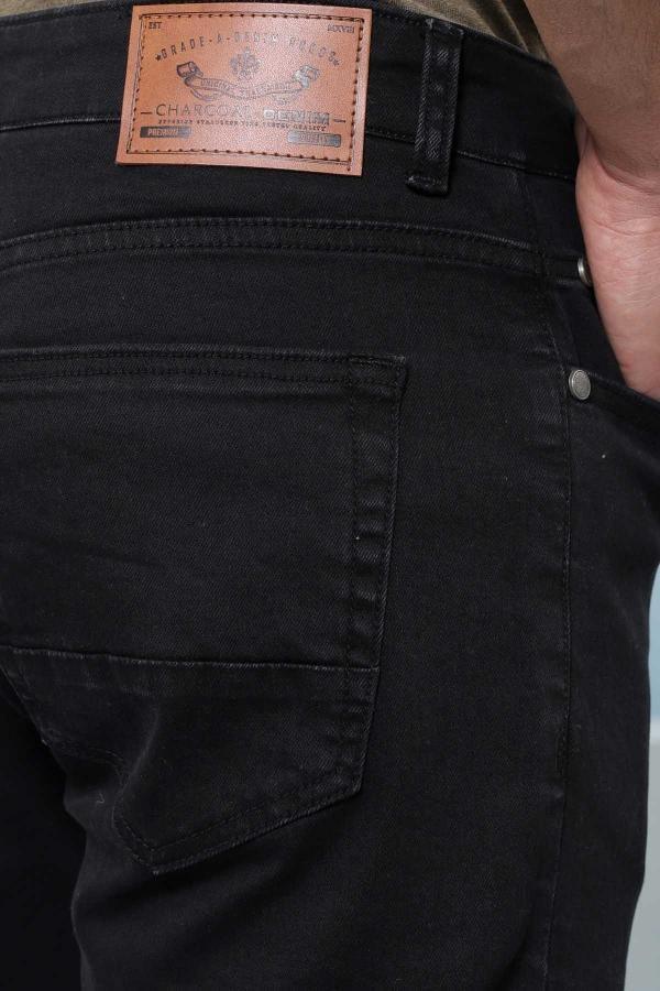 Denim shorts back pocket close-up with leather brand patch and stitching