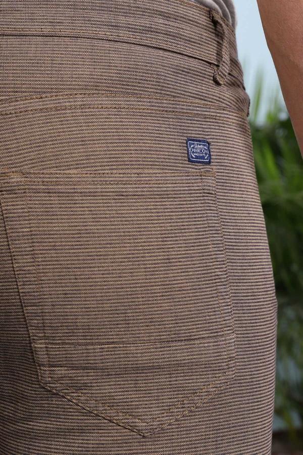 Brown shorts fabric close-up with small logo patch on pocket