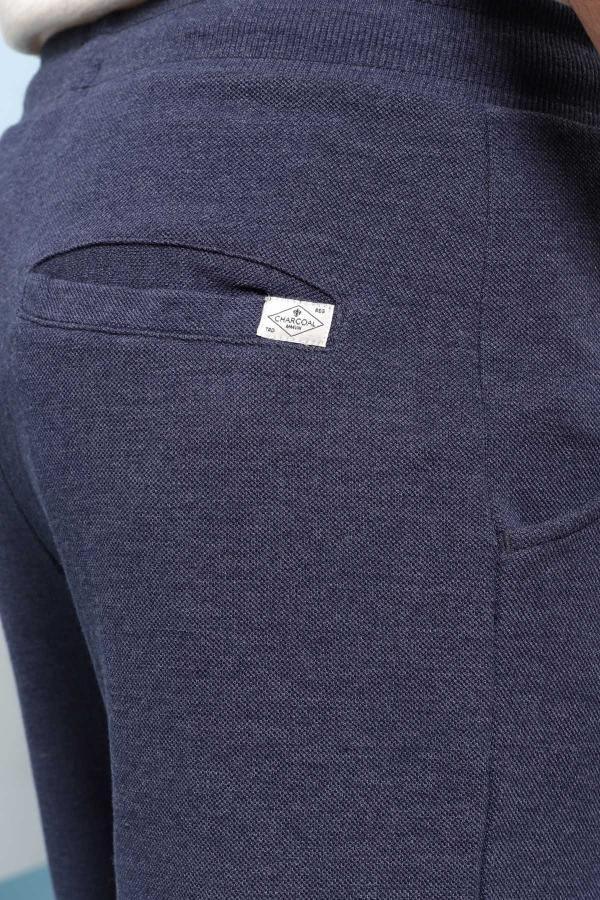 Indigo shorts close-up: woven fabric with side seam and logo patch near pocket