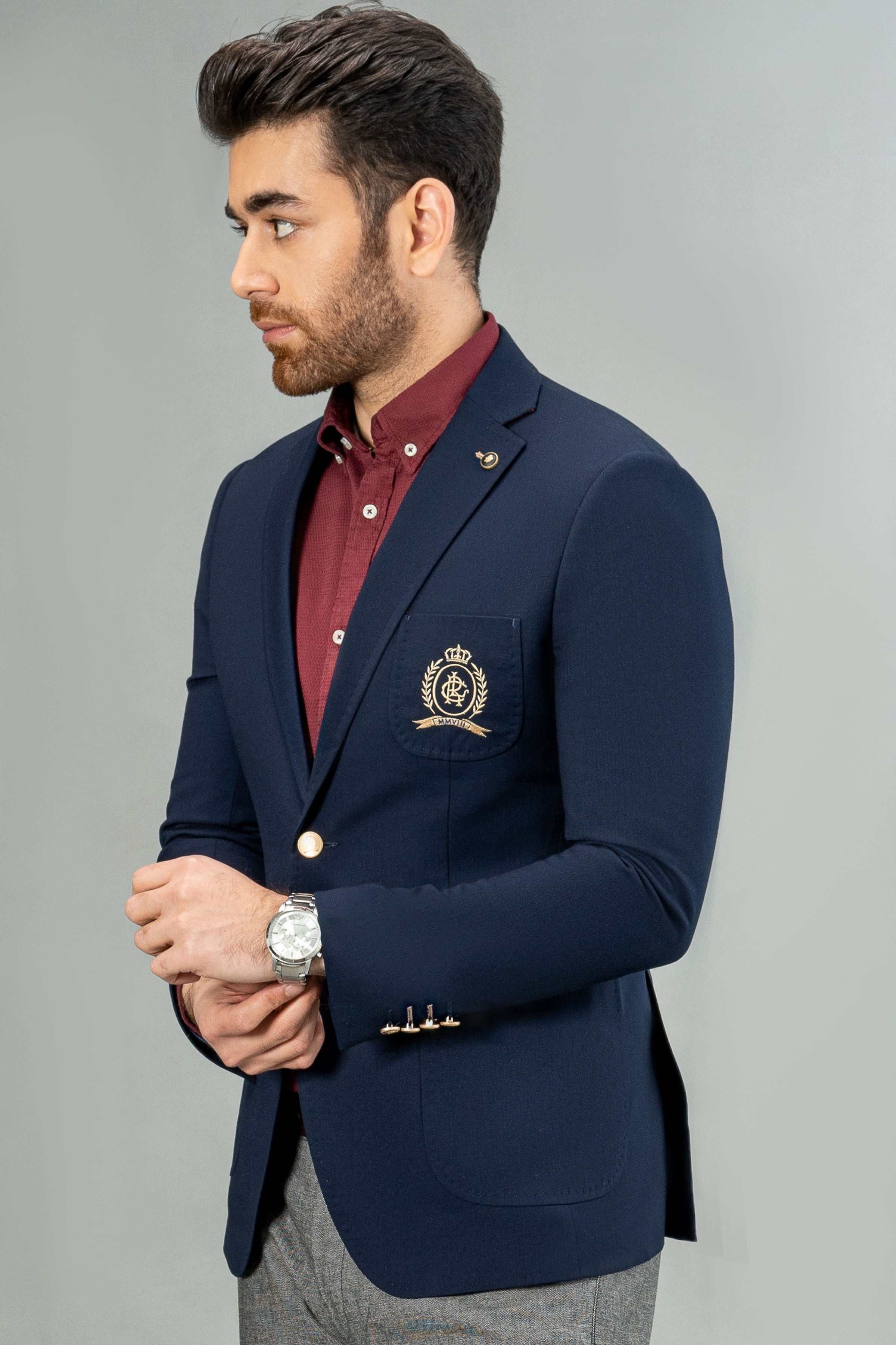 Navy casual coat with crest badge pocket, gold-button cuffs, and single-breasted front