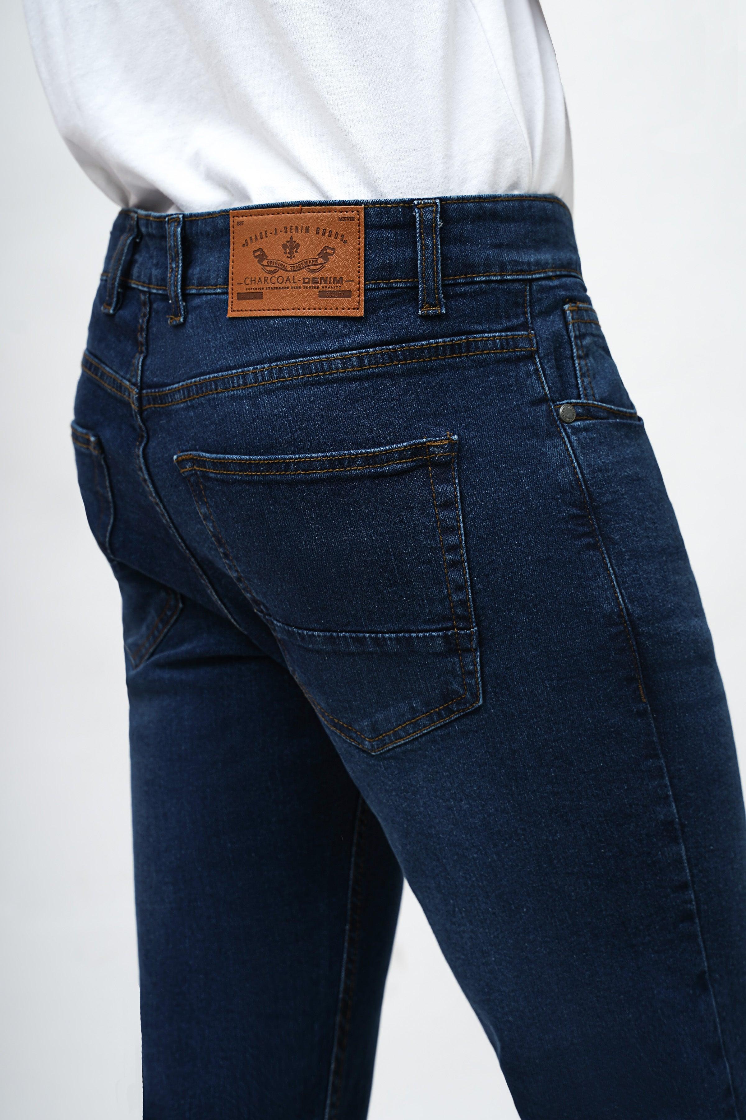 Dark blue skinny jeans close-up of front pockets and tan leather patch label