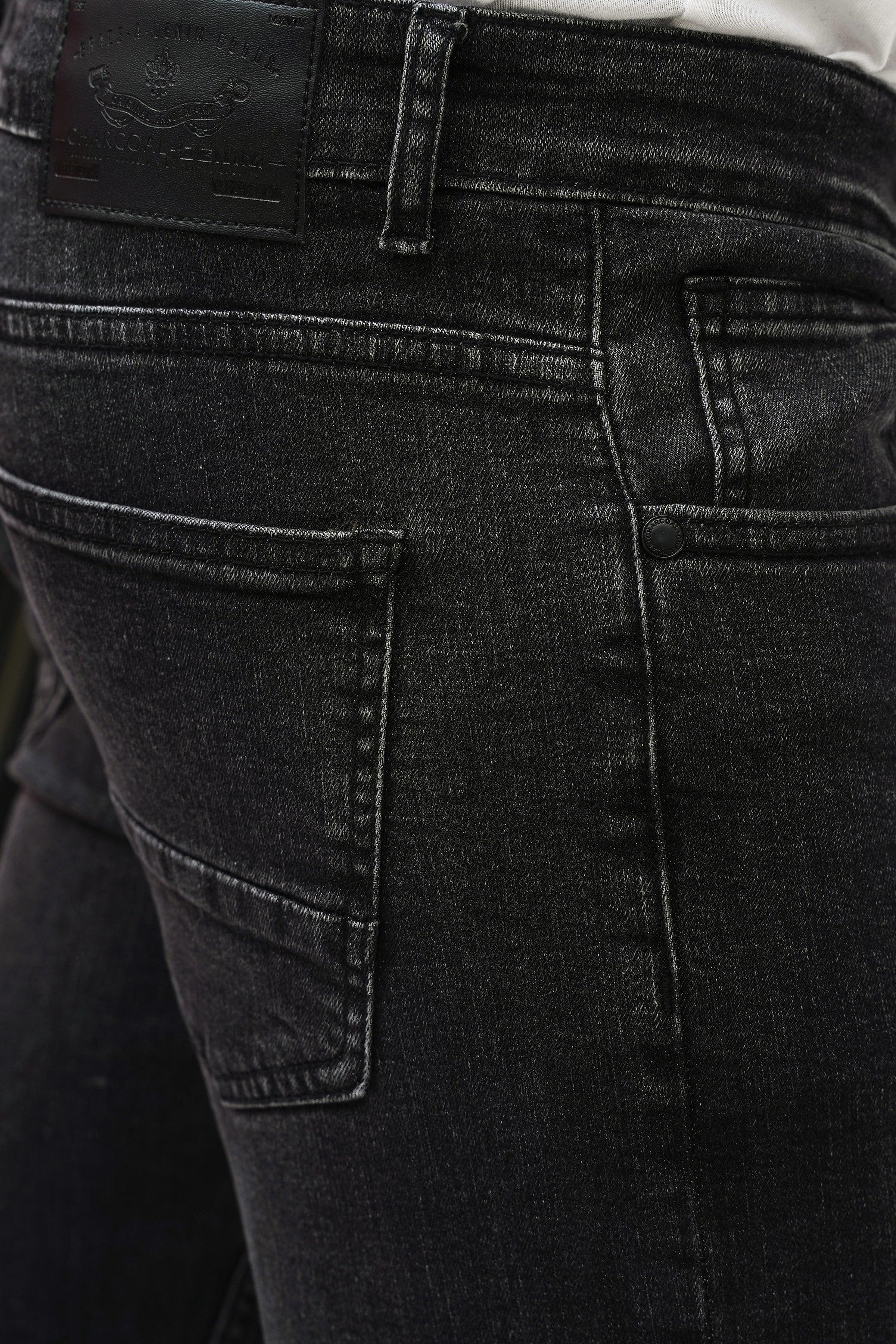 Dark grey denim jeans close-up of front pocket and waistband stitching