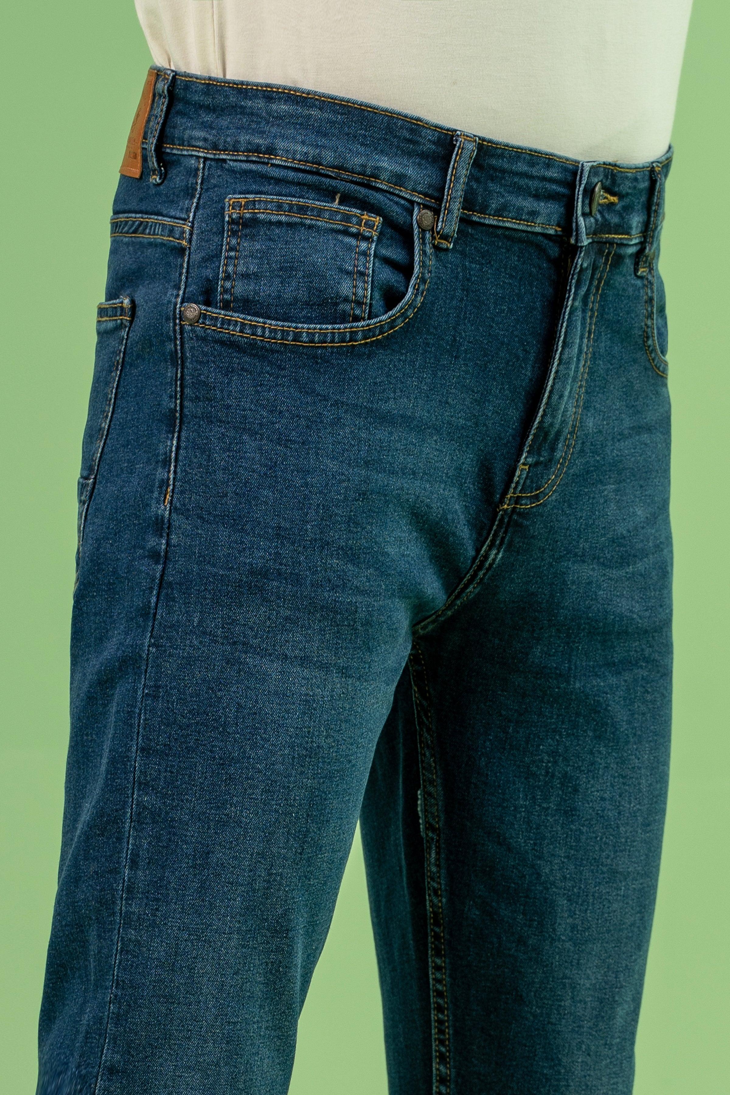 Dark blue denim jeans close-up of rear pocket, waistband stitching, and belt loops