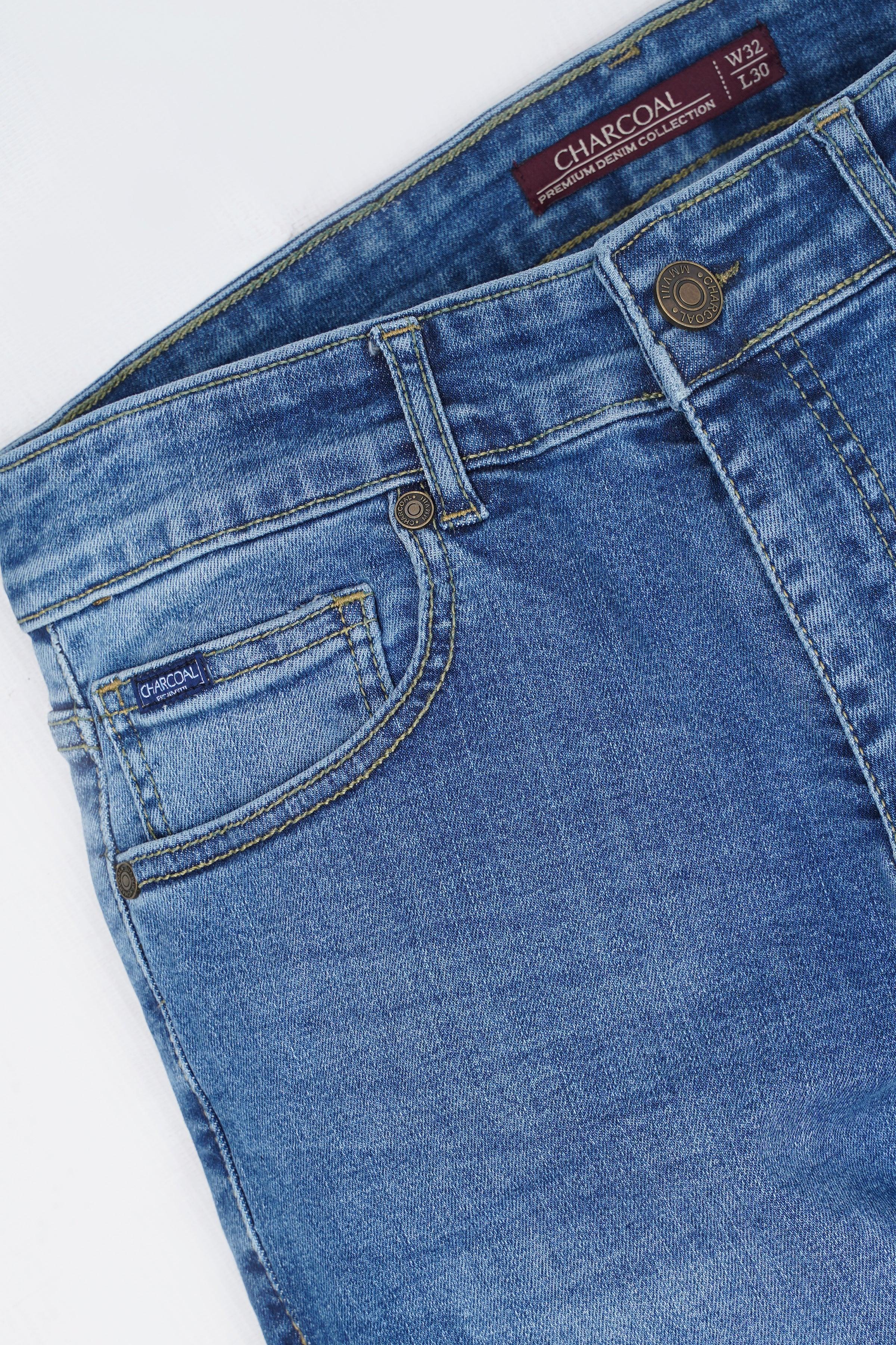 Mid-blue skinny jeans close-up of front pocket and metal button