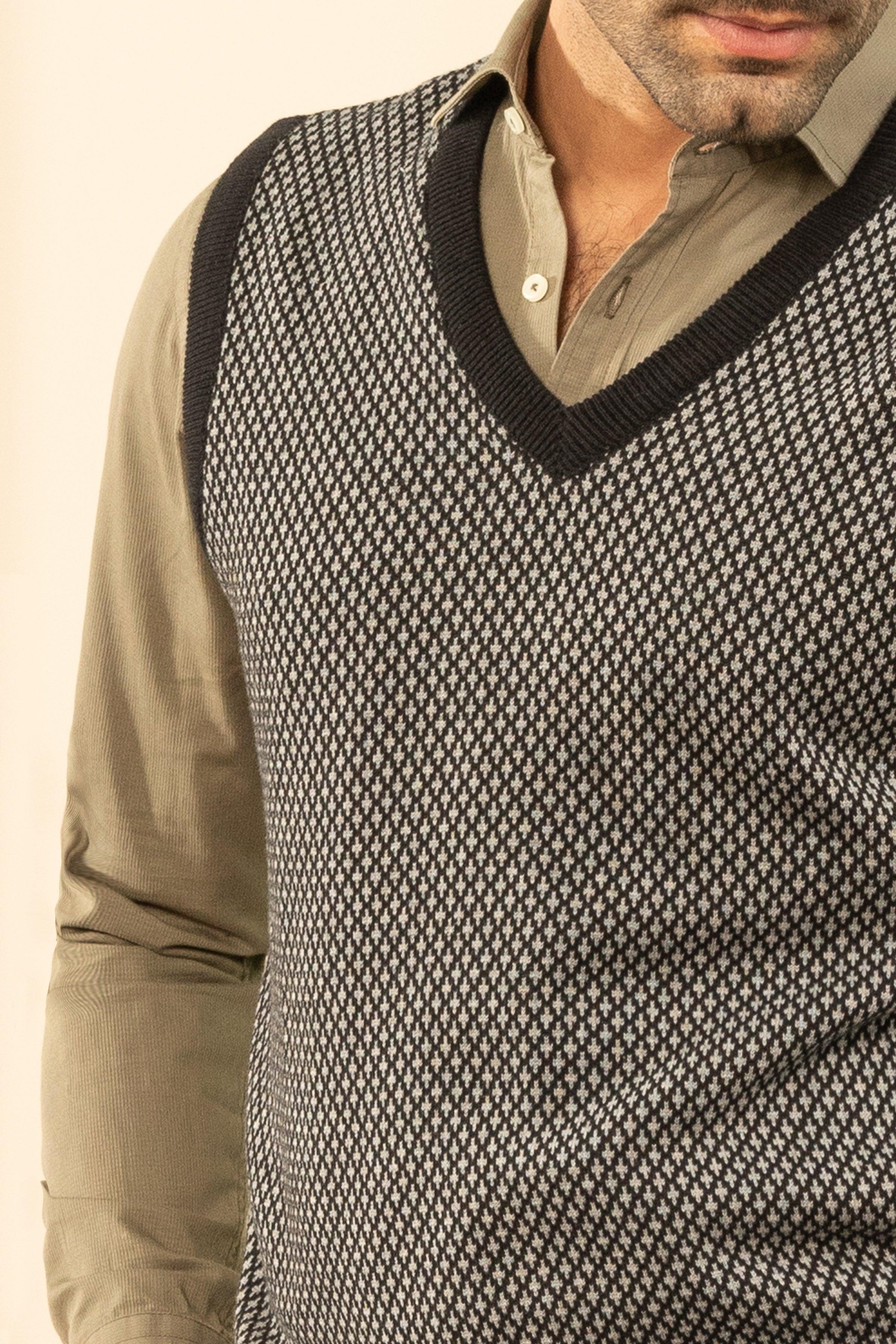 Sweater vest neckline close-up: V-neck with ribbed trim, dark gray textured knit.