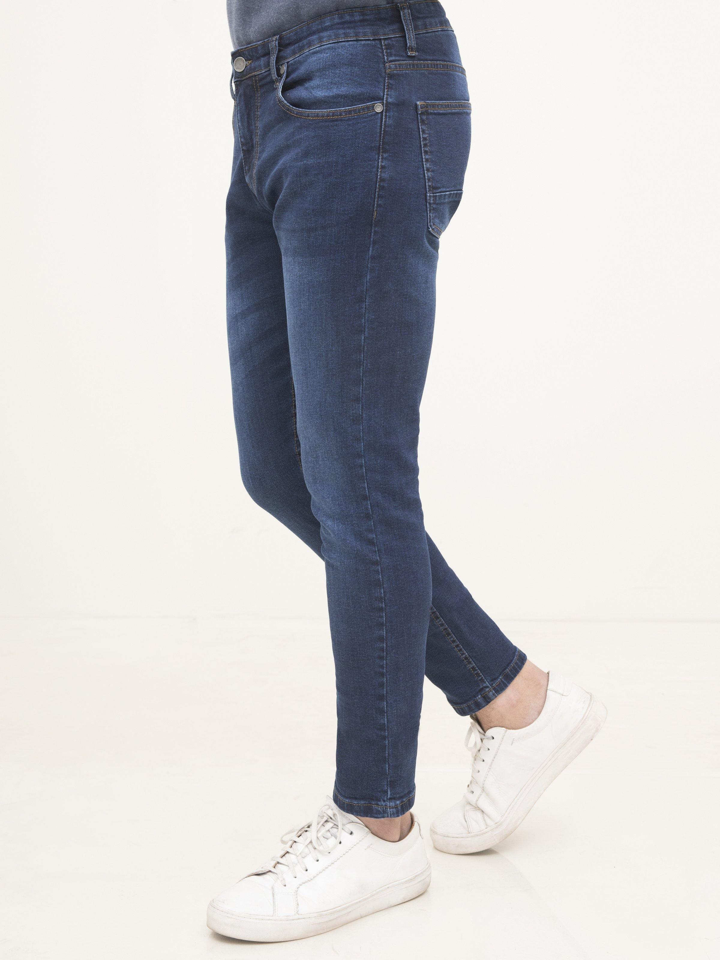 Dark blue slim-fit jeans, side view, zip fly and button closure