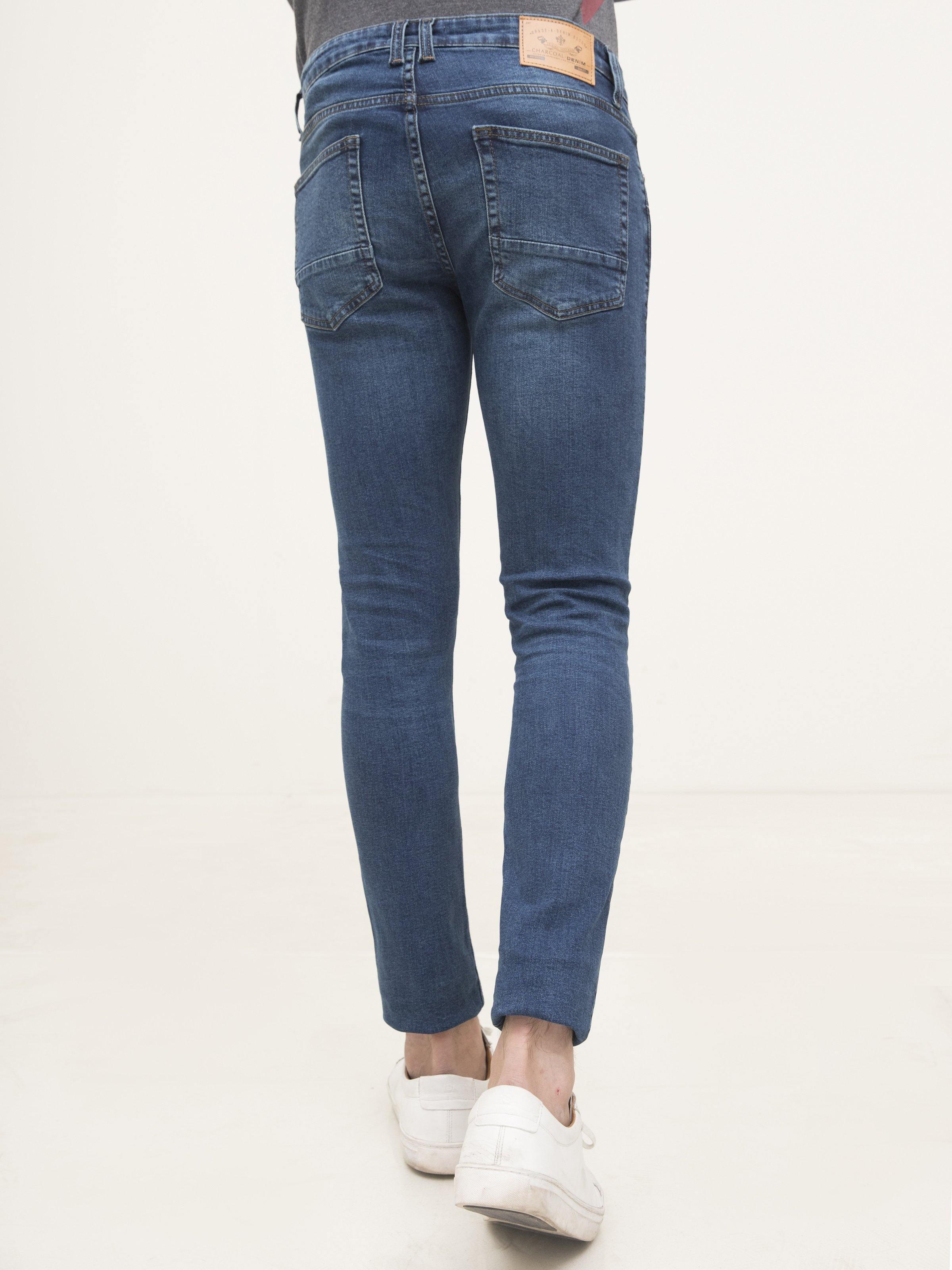 Slim-fit mid-blue jeans, back view with two back pockets and waistband stitching