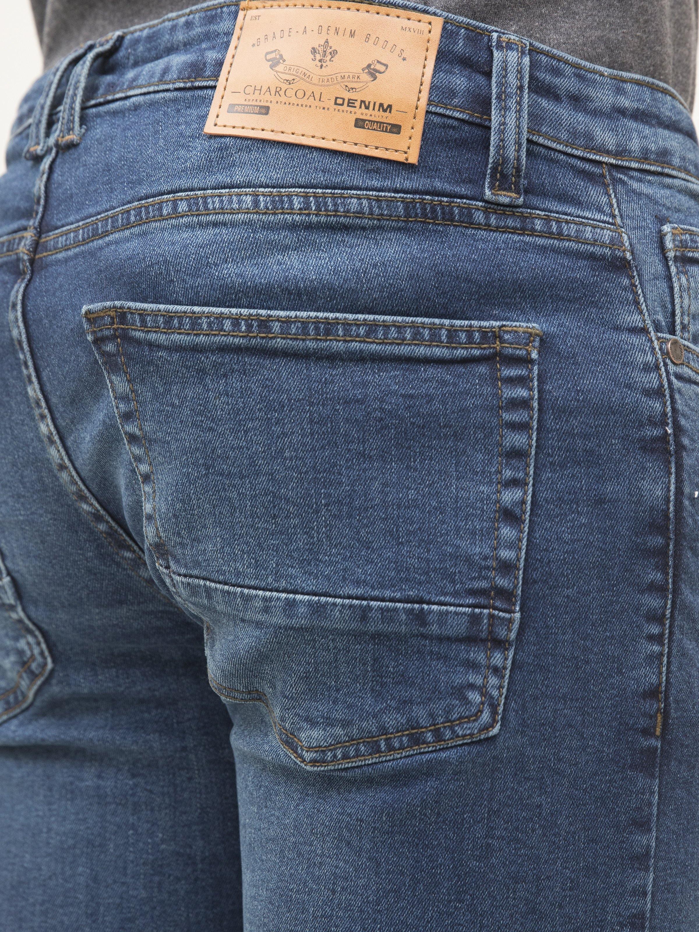 Mid-blue denim jeans close-up of back pocket and tan leather waistband label