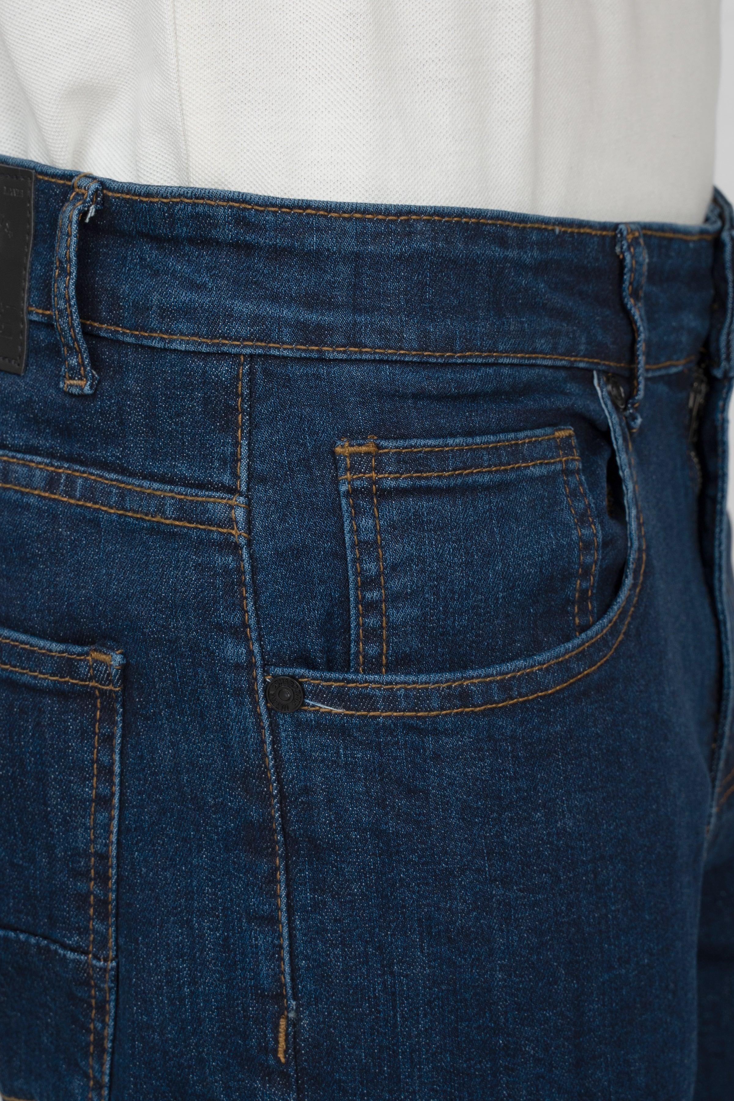 Dark blue denim jeans close-up of front pocket and belt loops