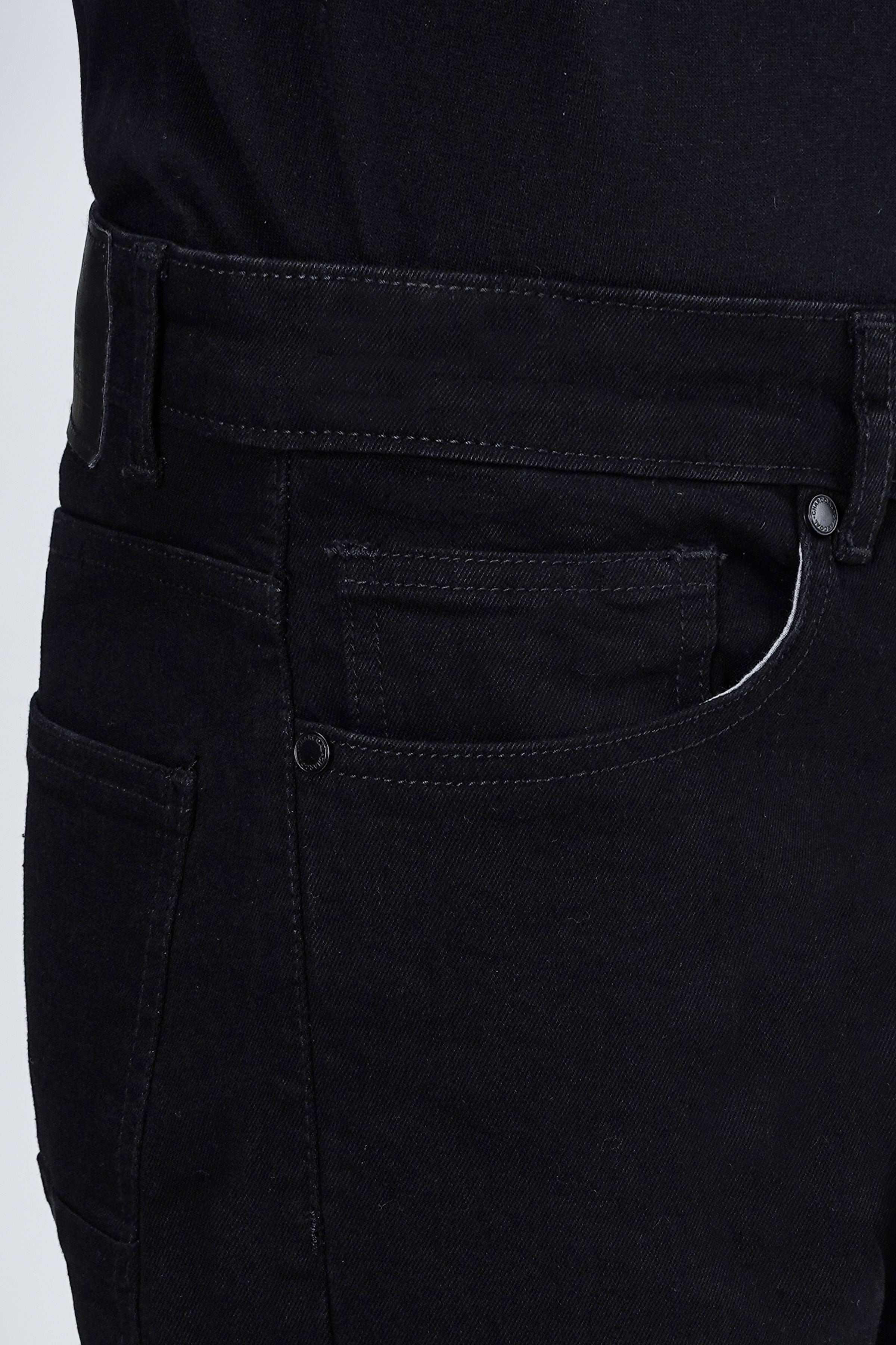 Black denim jeans close-up showing front pocket and buttoned waistband details