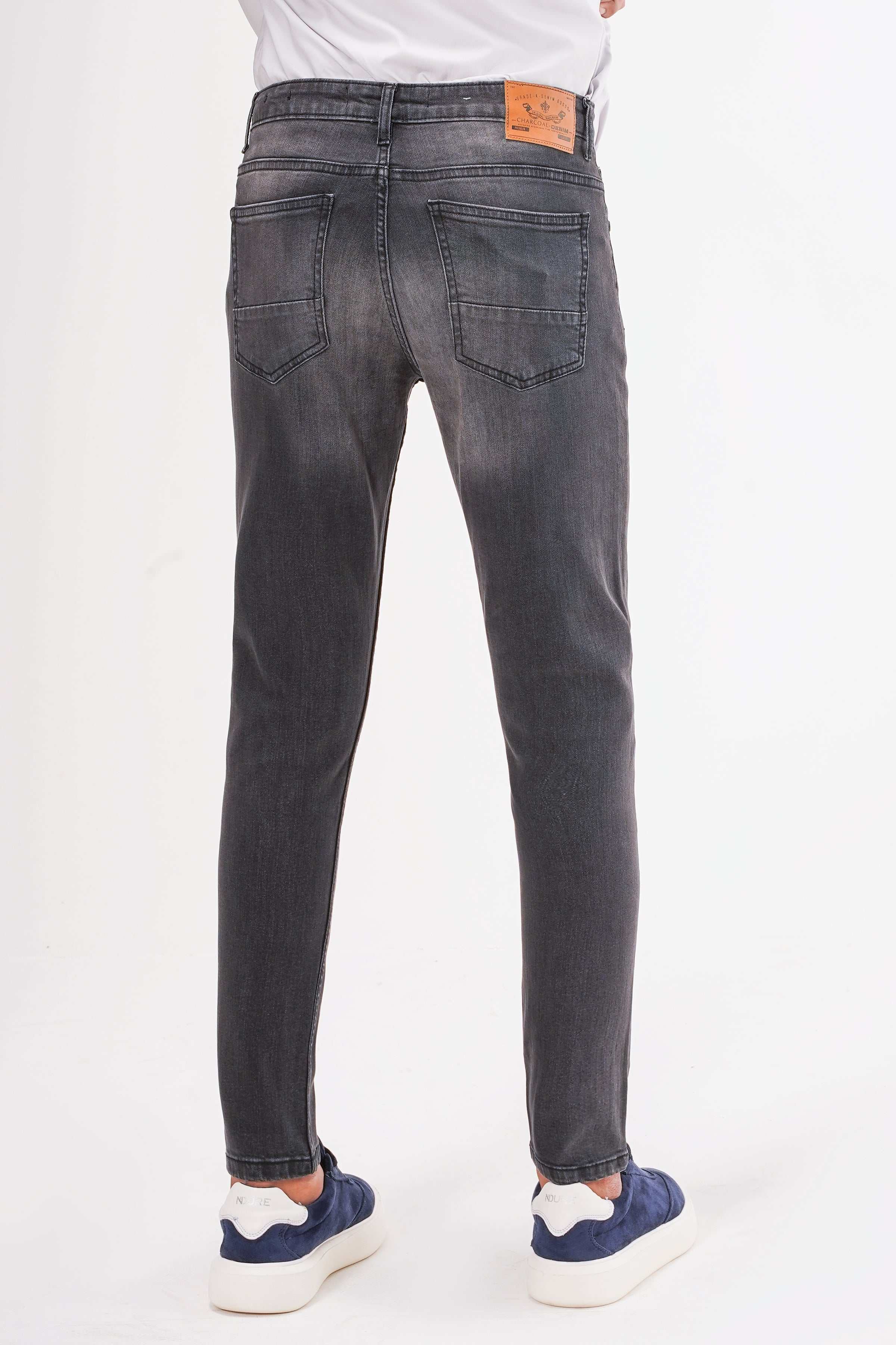 Dark grey slim-leg jeans back view with rear pockets and orange waistband patch