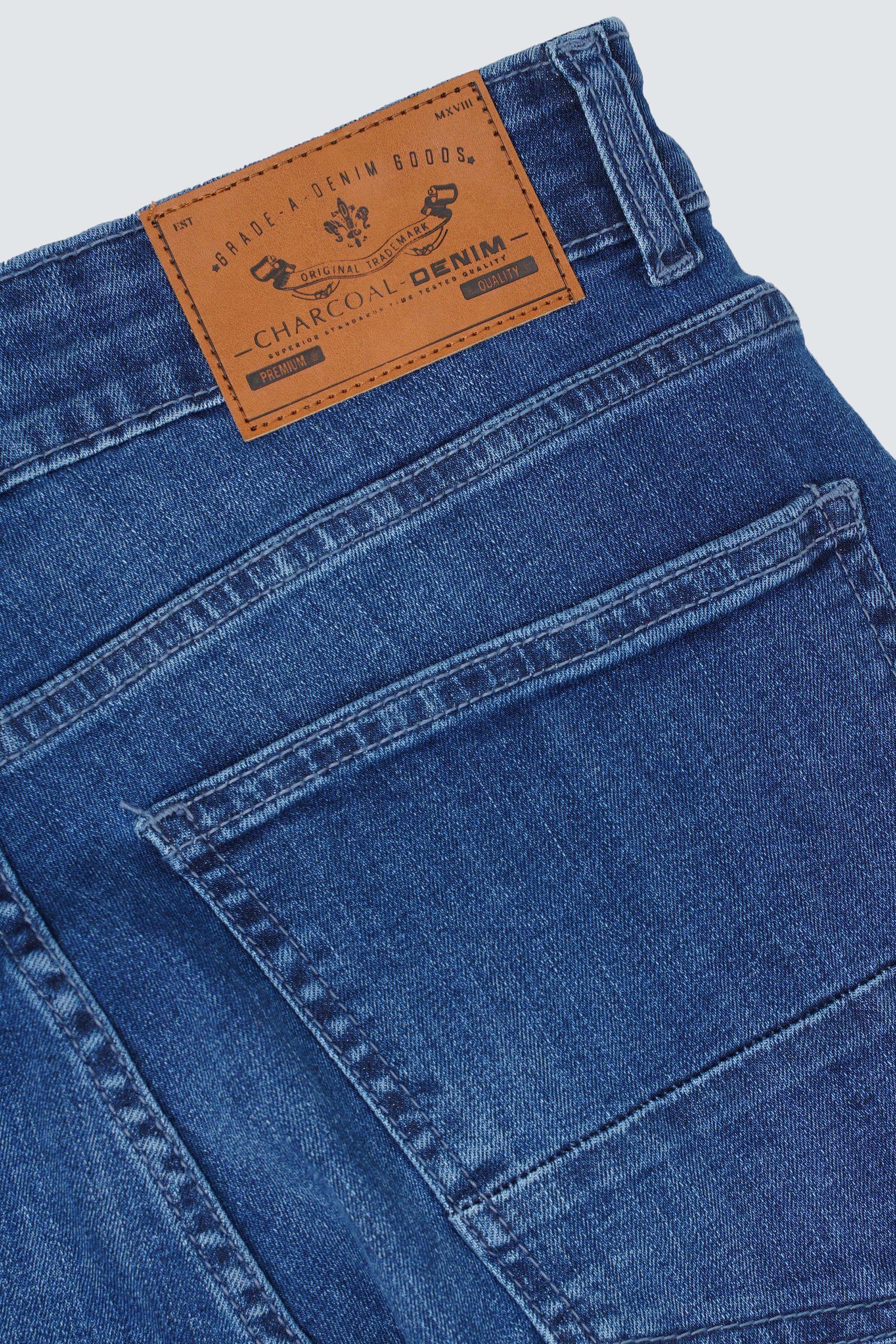Light blue denim jeans close-up of leather brand patch and stitched pocket
