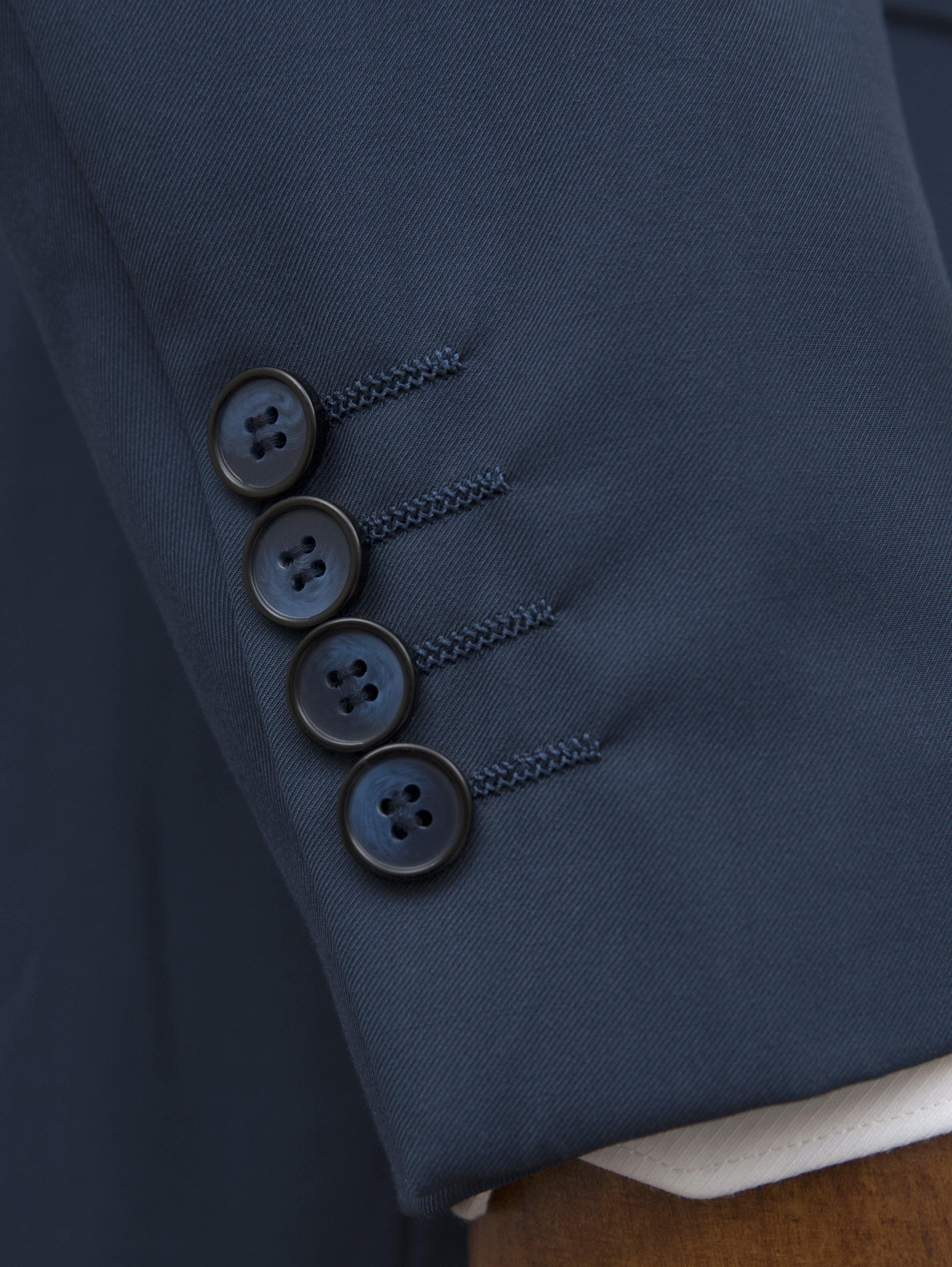 Blue suit jacket sleeve with four buttons, close-up