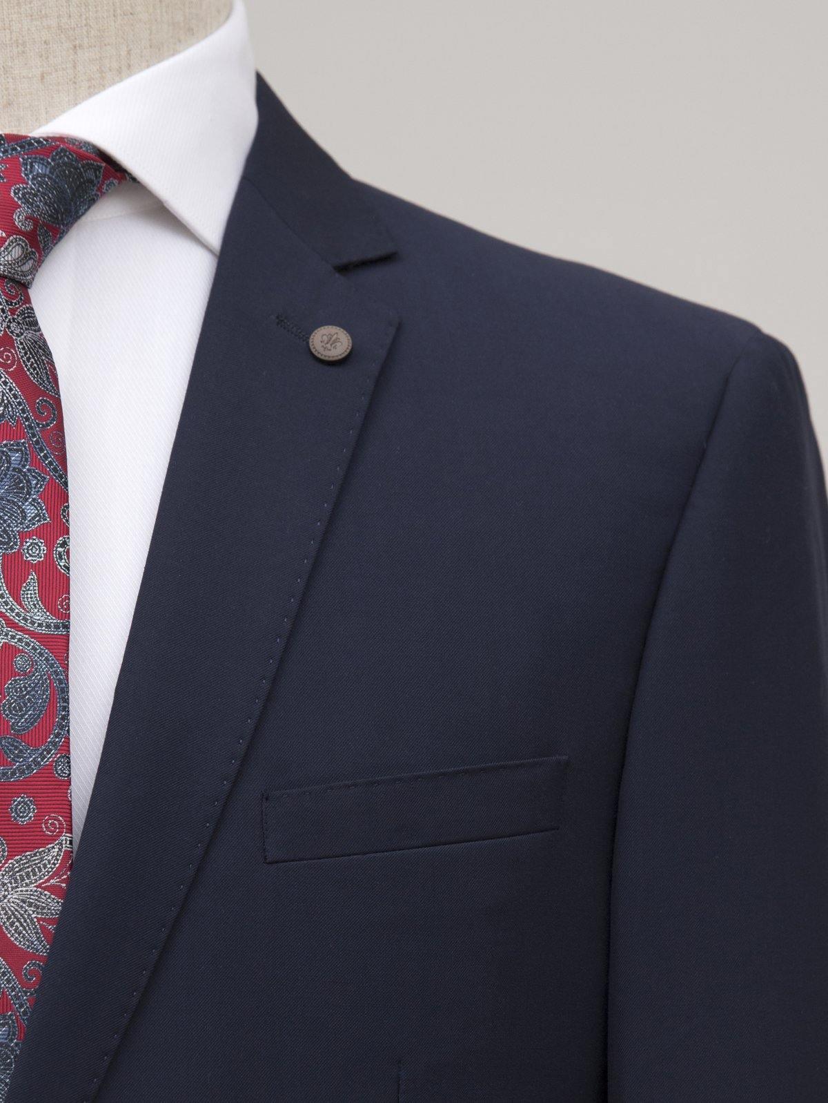 Navy suit jacket lapel and breast pocket with decorative button