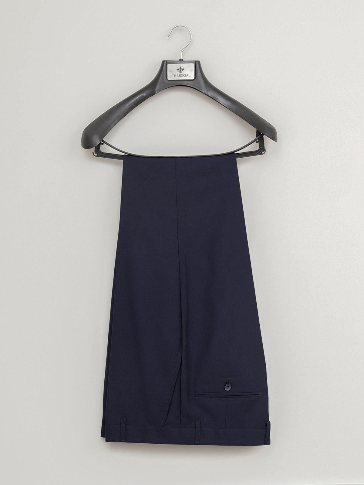 Navy suit trousers on a hanger with front pleats and waistband pocket flap