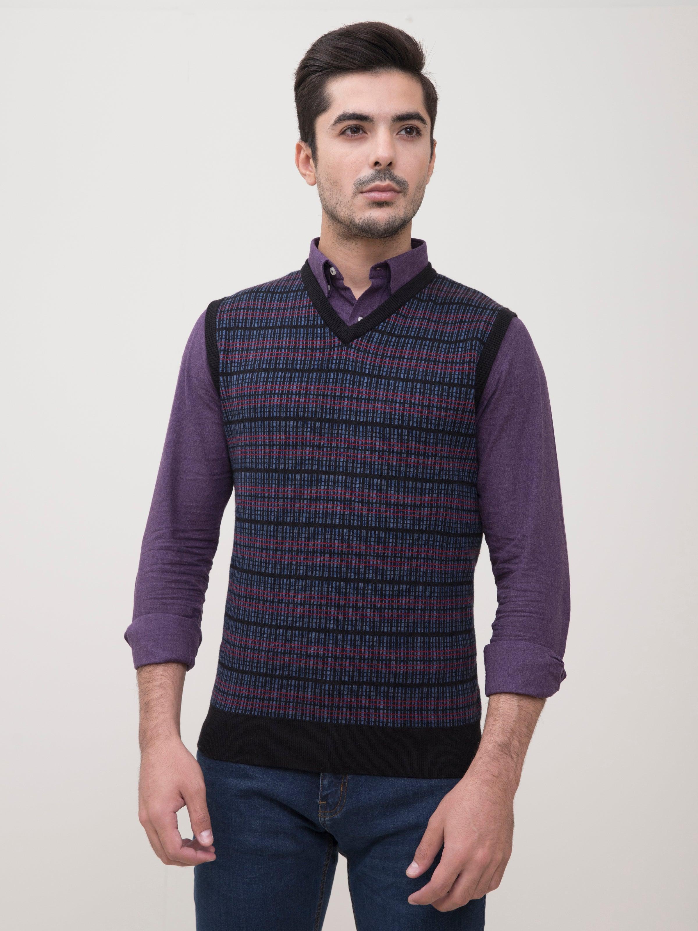 Men’s striped knit V-neck sweater vest over long-sleeve shirt, purple tones