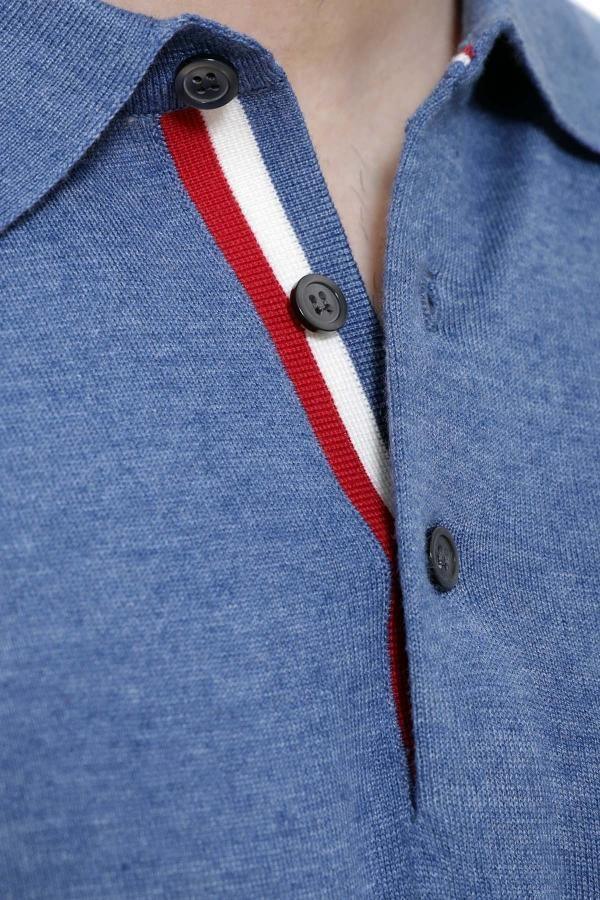 Blue polo placket close-up with red-and-white stripe and black button