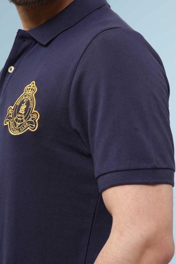Navy polo shirt sleeve with gold crest patch