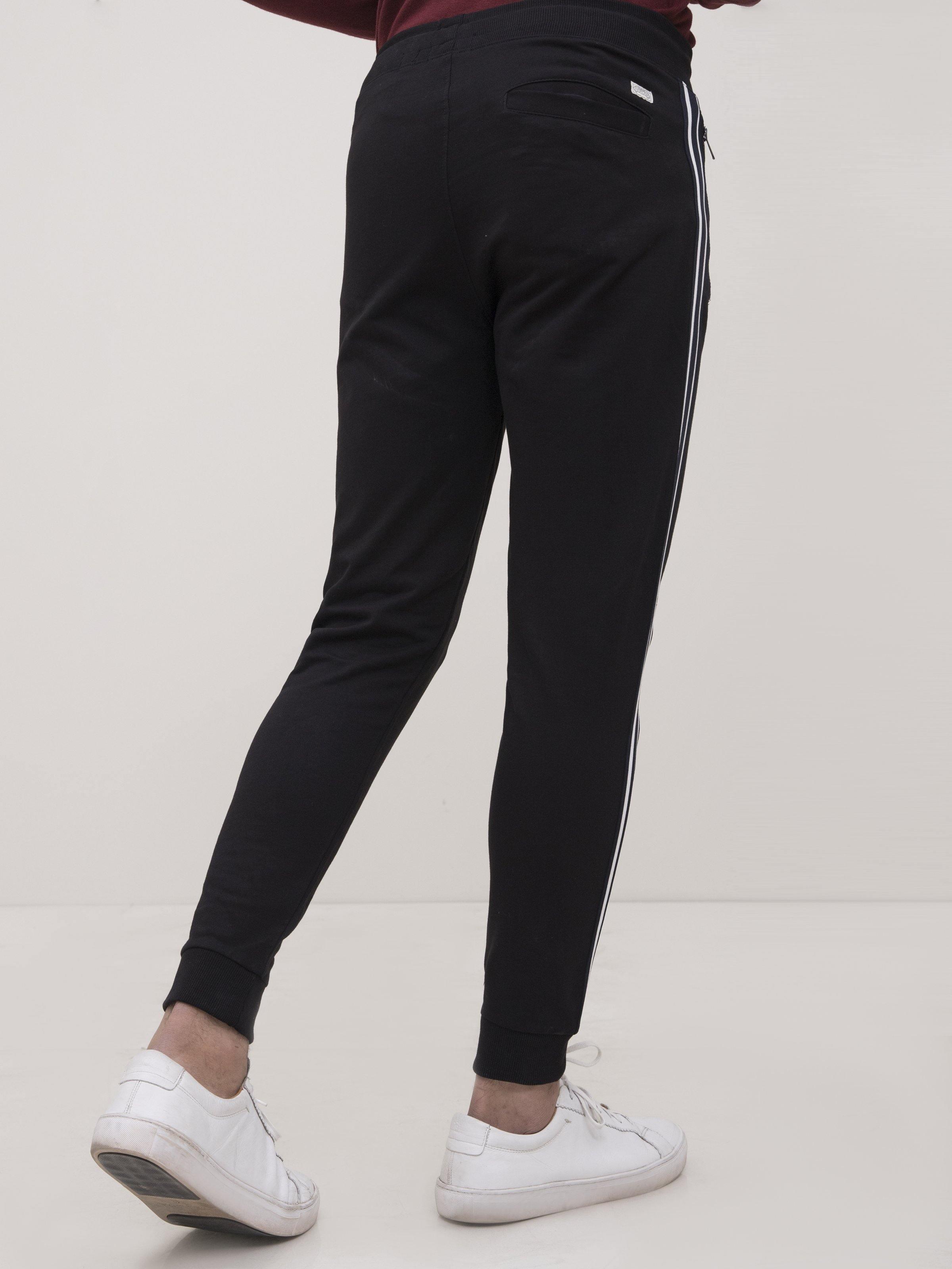 Black jogger trousers with long white side stripes and tapered ankle