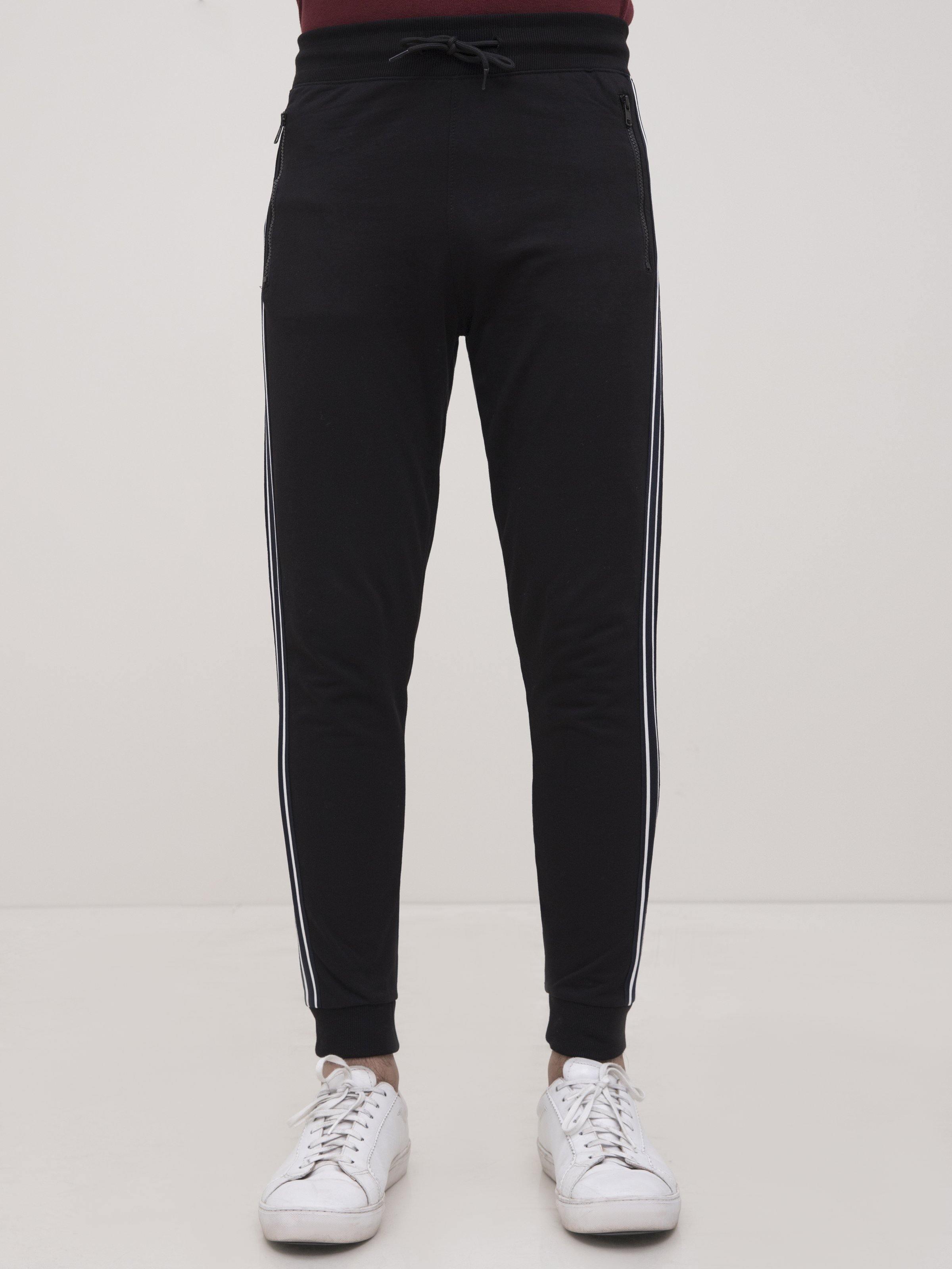 Black jogger trousers with two white side stripes, elastic waistband, ankle cuffs