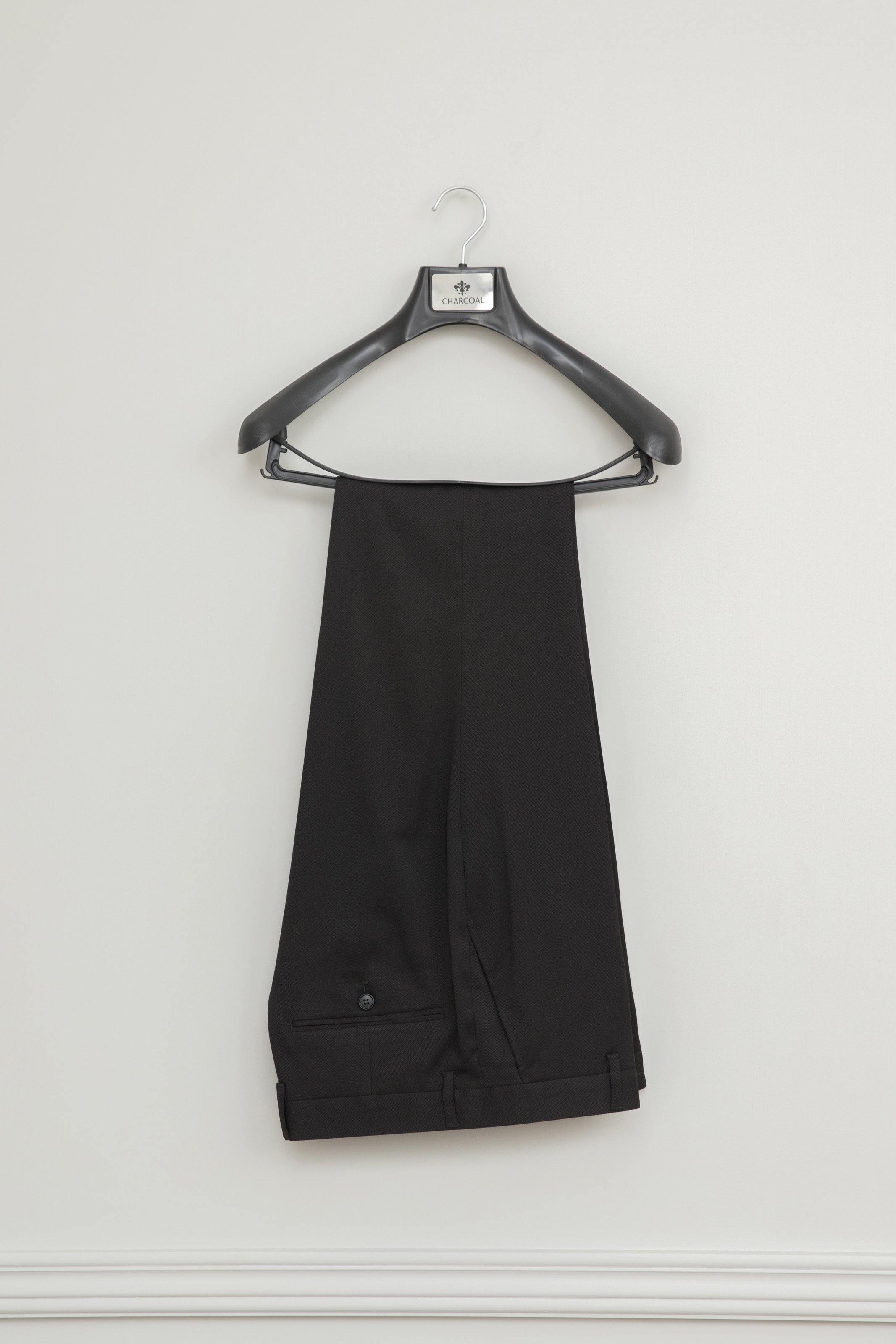 Black tuxedo trousers hanging on a hanger