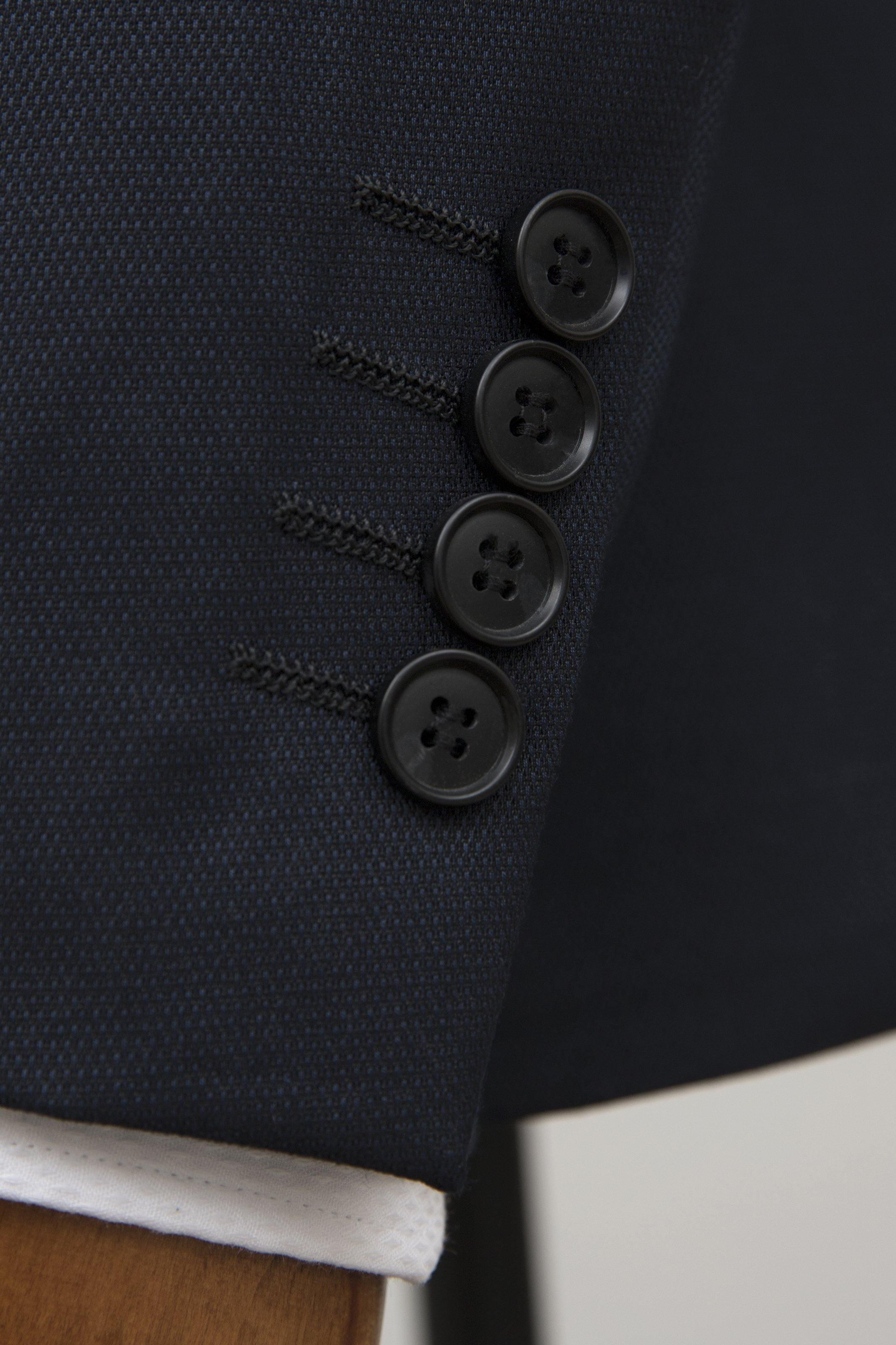 Navy tuxedo jacket front with four-button closure detail