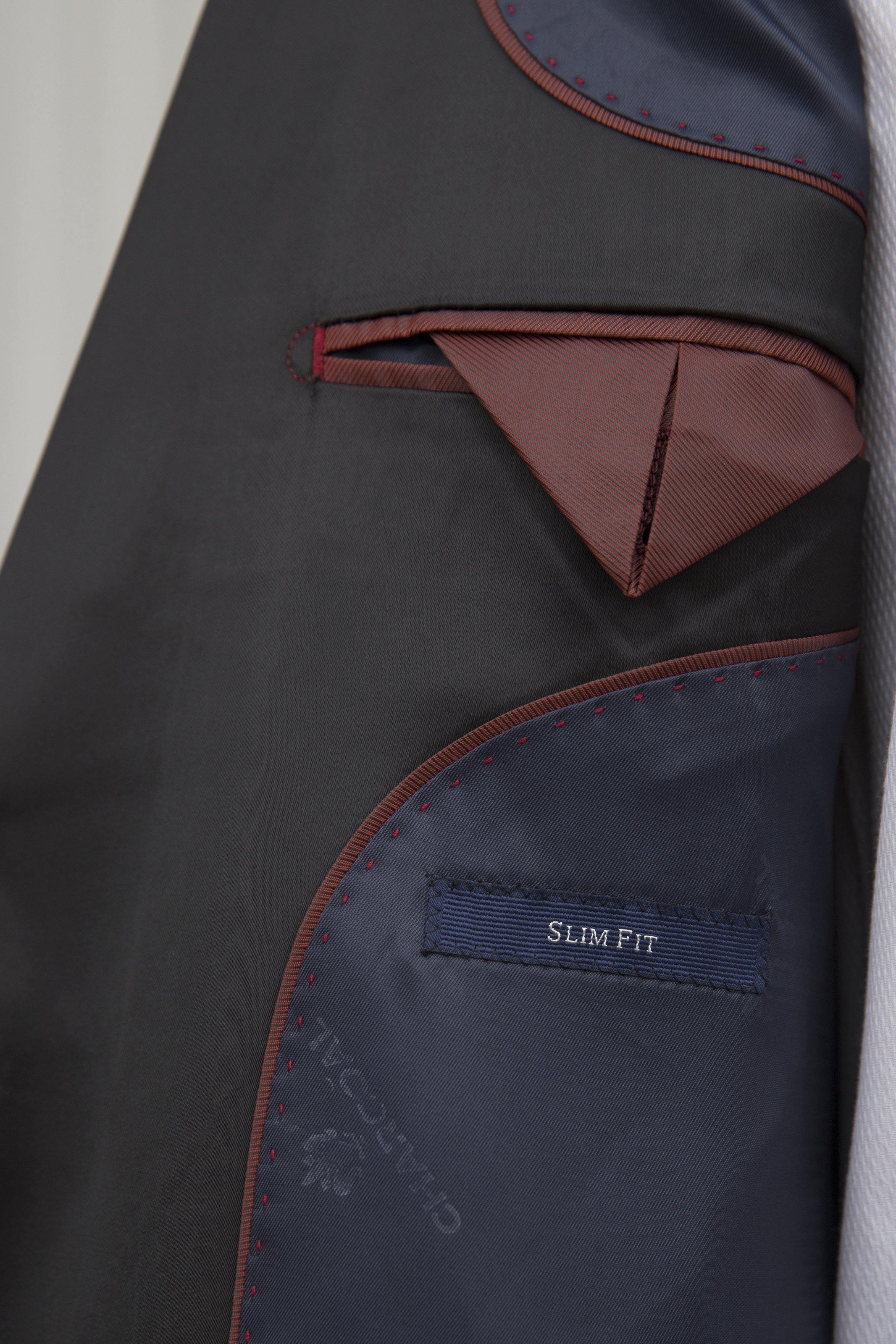 Navy tuxedo jacket interior with red trim and "SLIM FIT" label