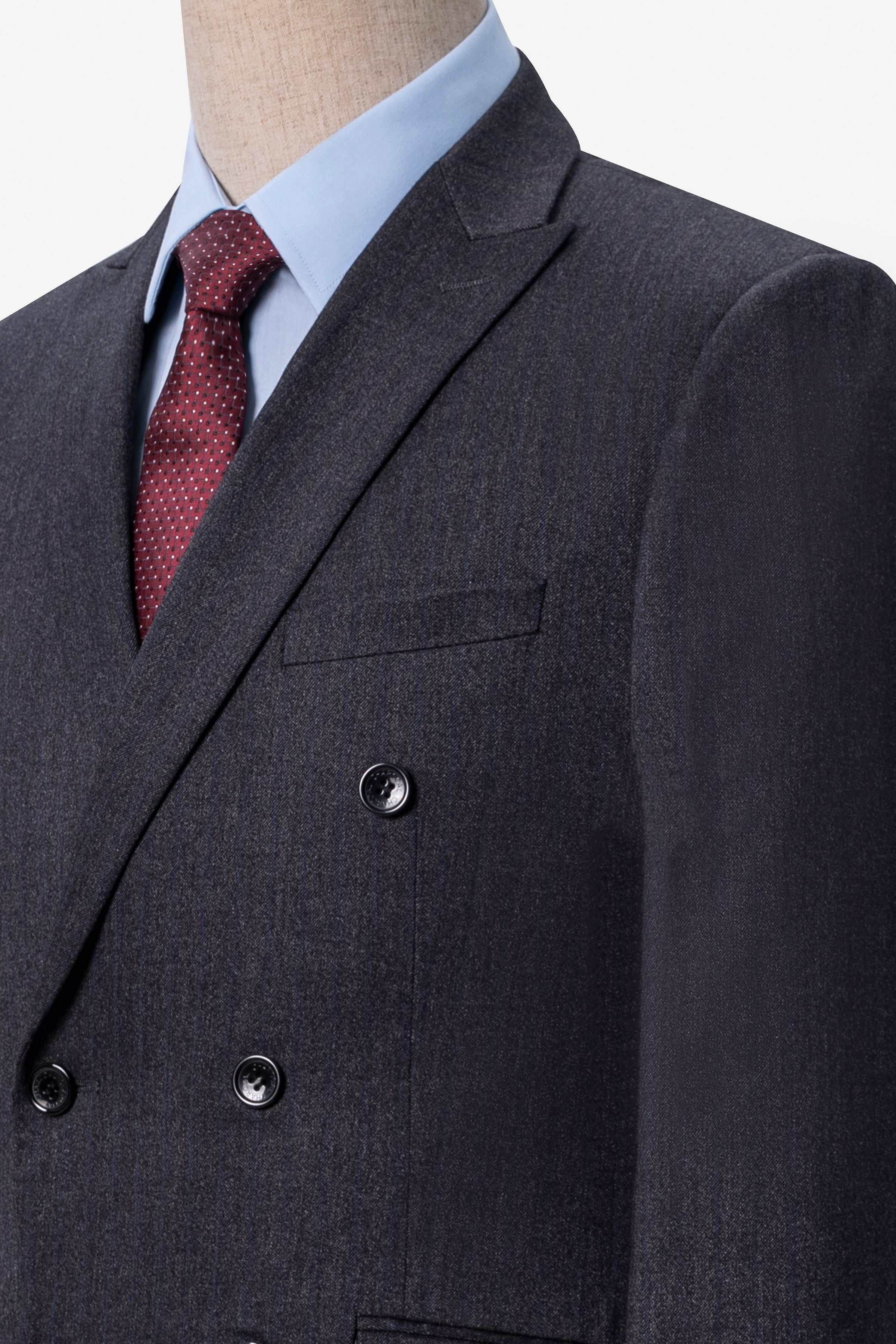 Charcoal suit jacket detail with notched lapel, pocket flap, and dark buttons