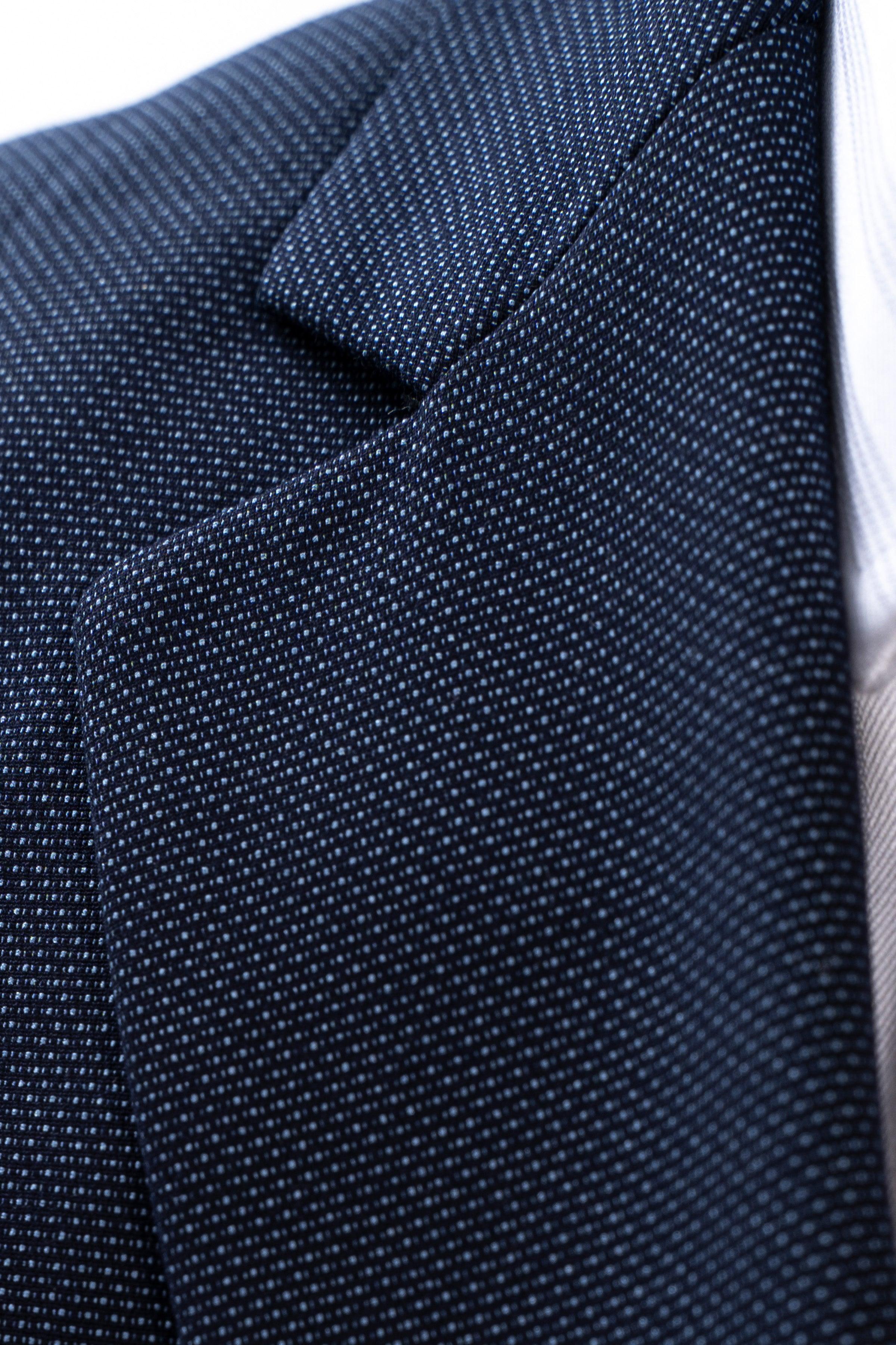 Dark blue suit jacket shoulder fabric close-up with subtle check texture