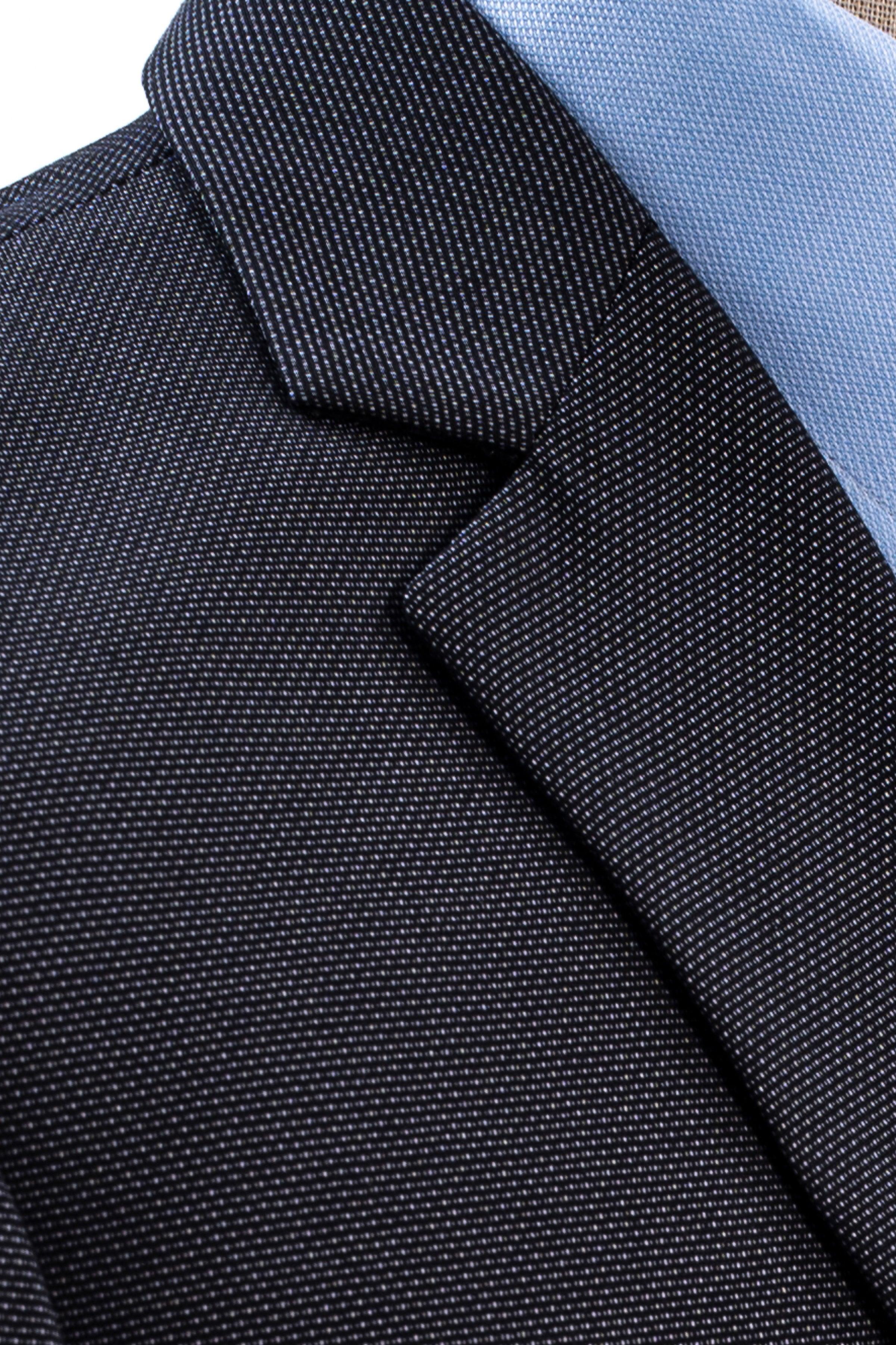 Slim fit suit jacket lapel and collar seam, textured dark fabric