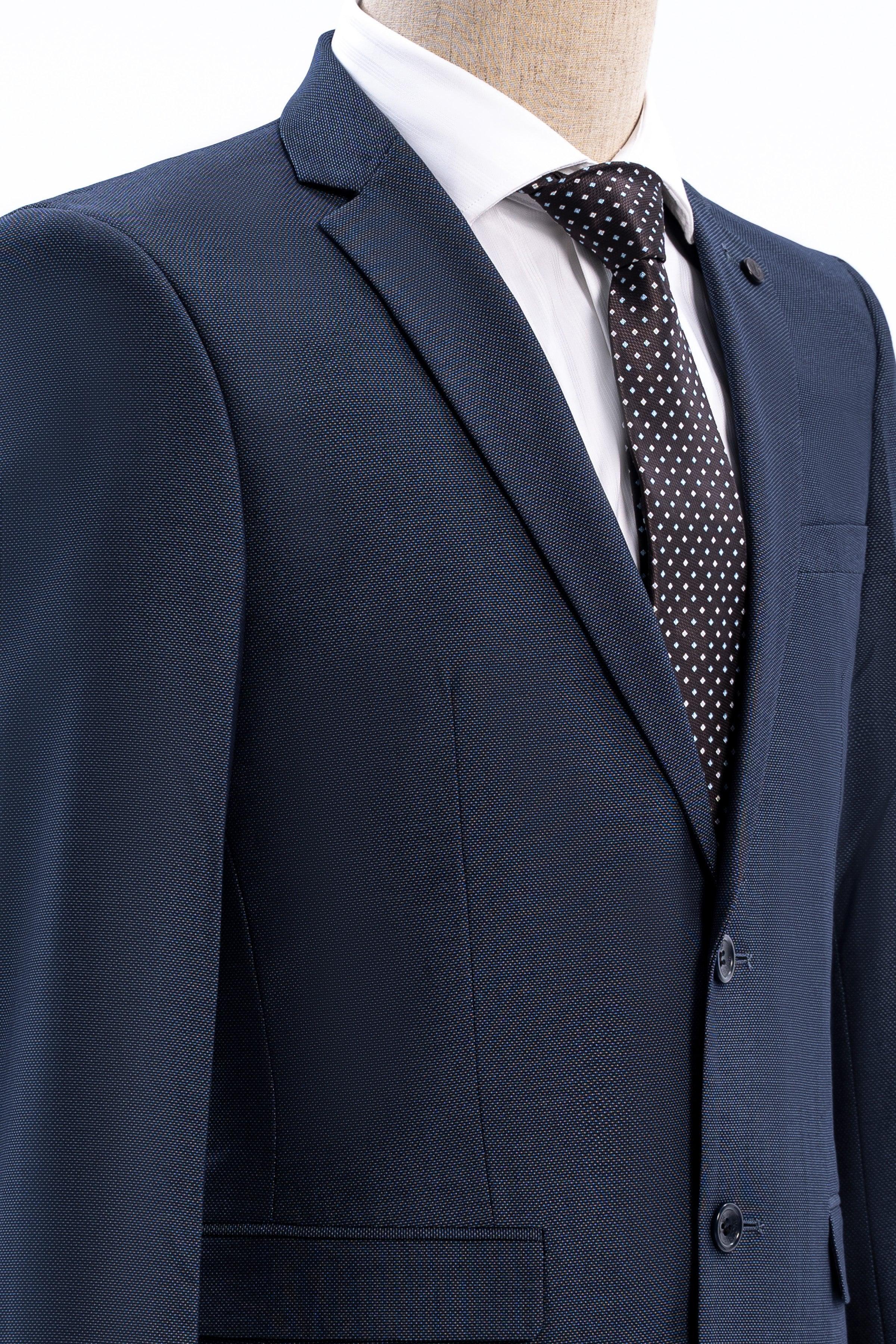 Dark blue slim-fit suit jacket lapel with white shirt and patterned tie