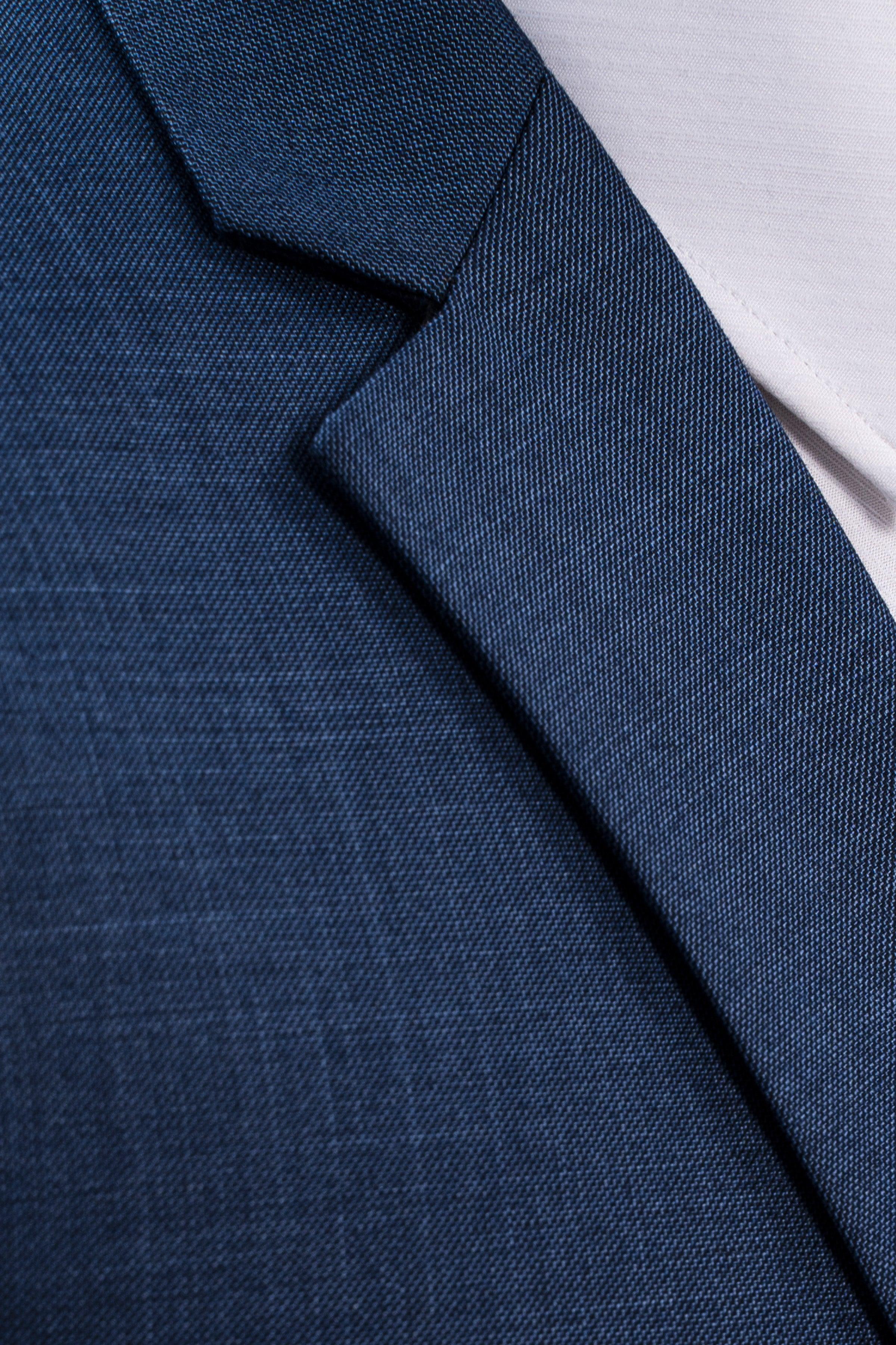 Blue suit jacket fabric and lapel edge close-up