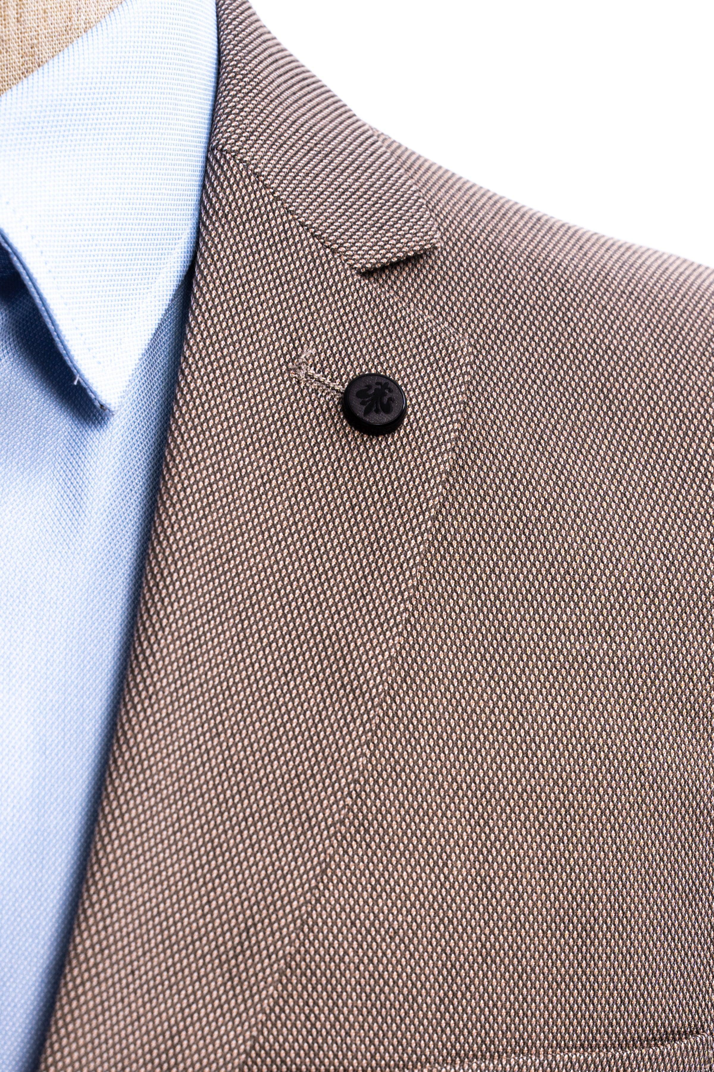 Taupe suit jacket with black button and light blue dress shirt cuff