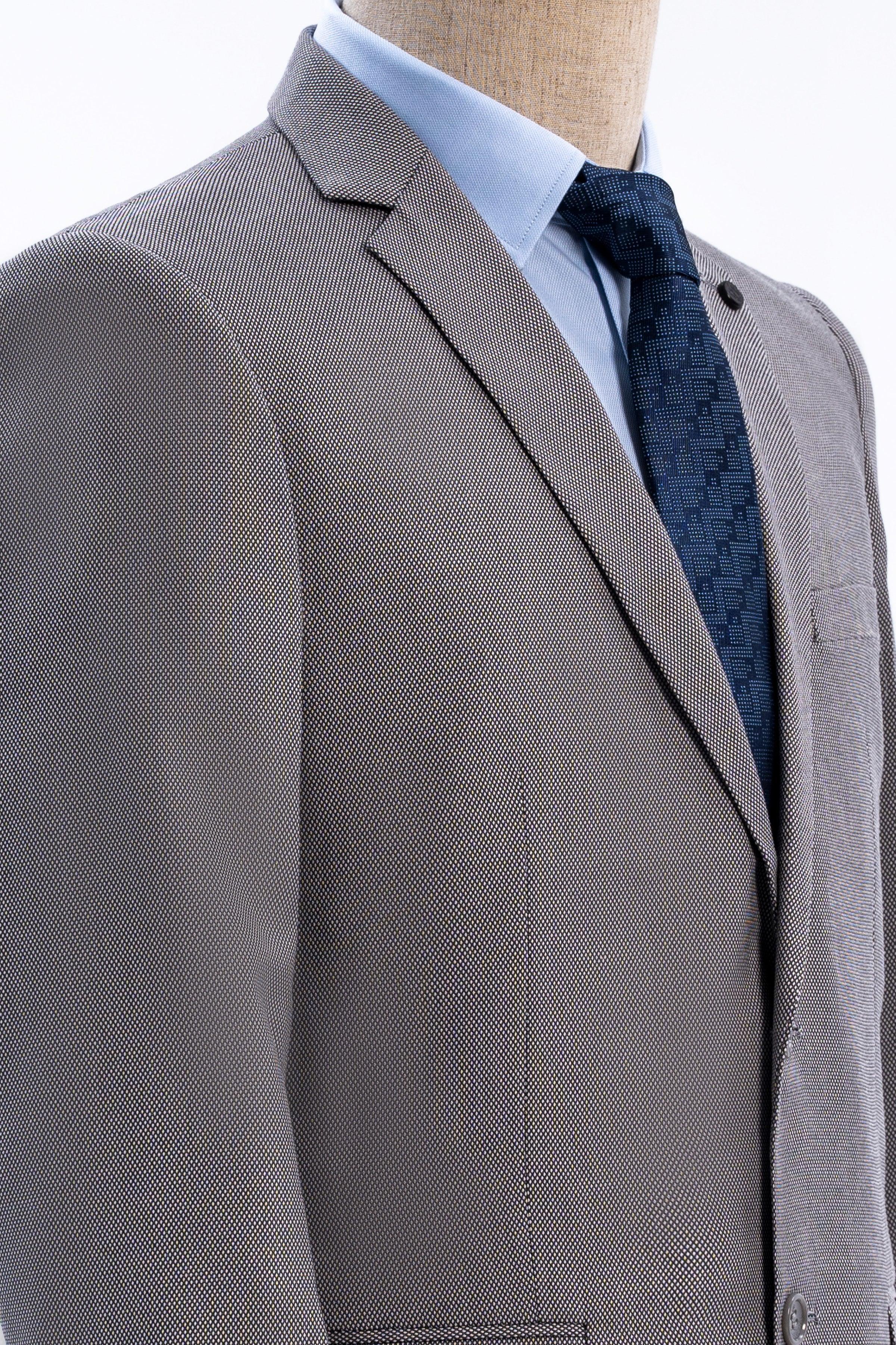 Suit jacket lapel and shoulder in medium gray with dark patterned tie at neckline