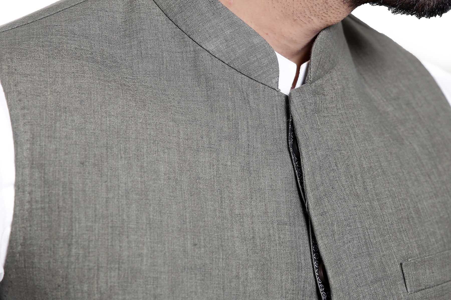 Green waist coat close-up: stand collar, zipper placket, and textured fabric