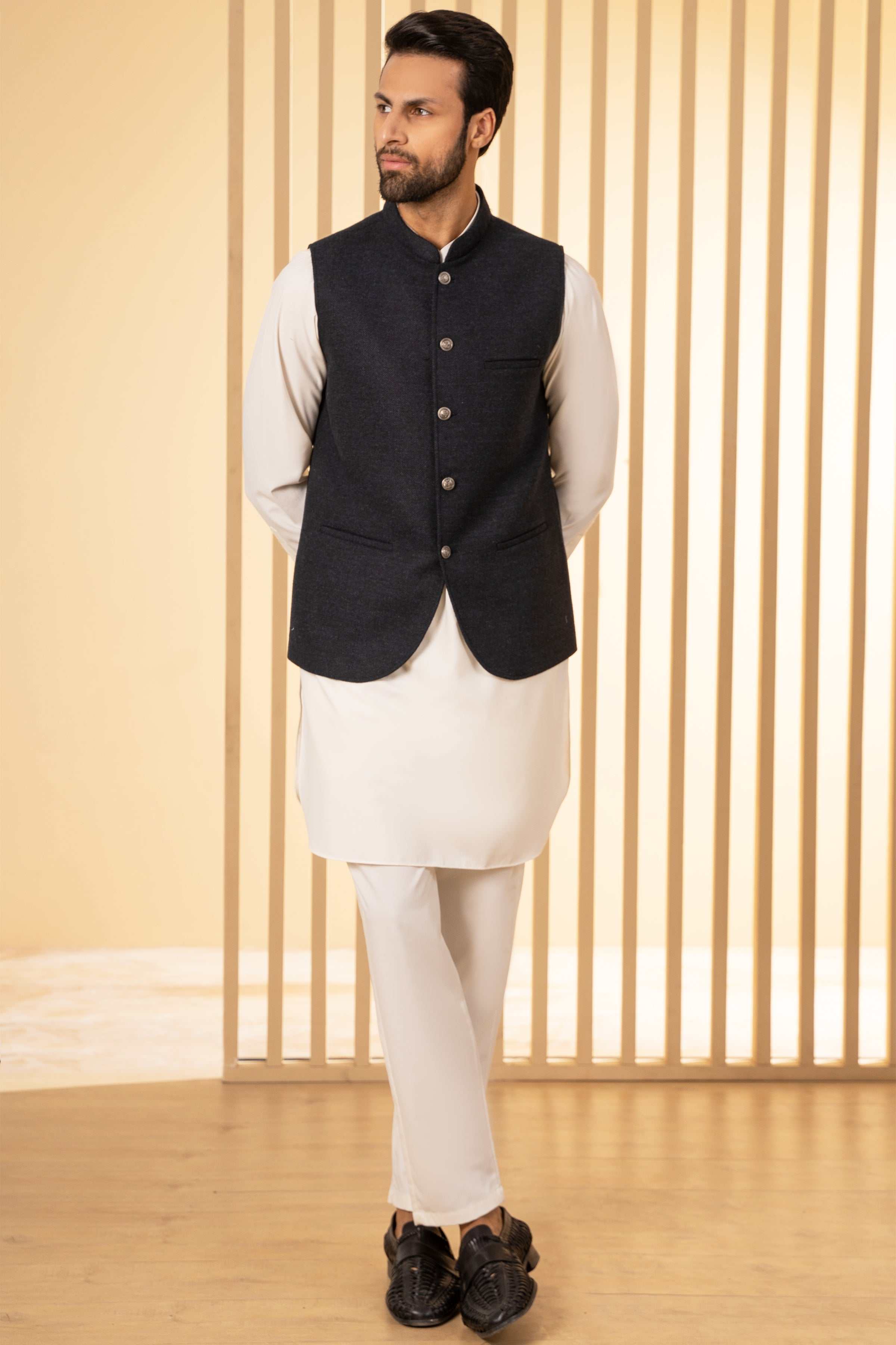 Blackish-blue waistcoat, front button placket and pocket, worn over white sleeves.