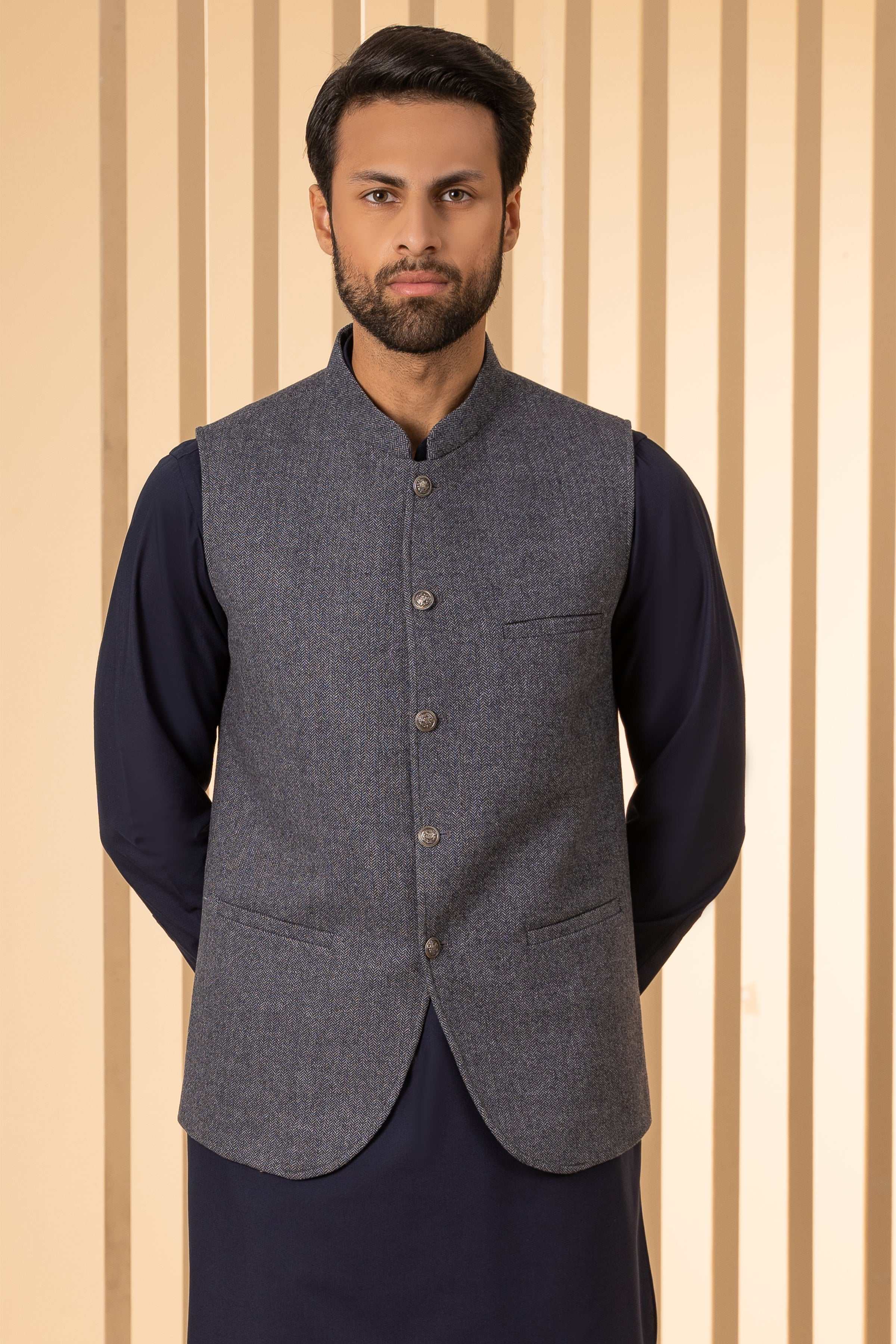 Grey herringbone sleeveless waistcoat with four-button placket and chest pocket