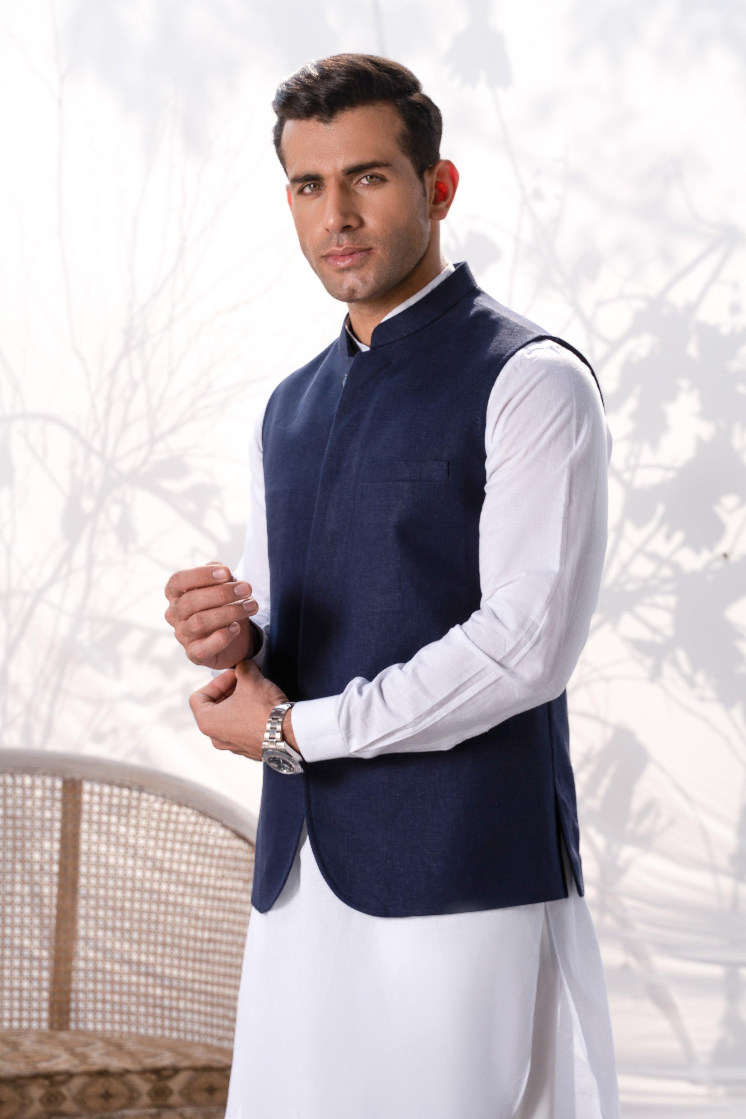 Navy waistcoat worn over a white dress shirt, sleeveless front with button placket