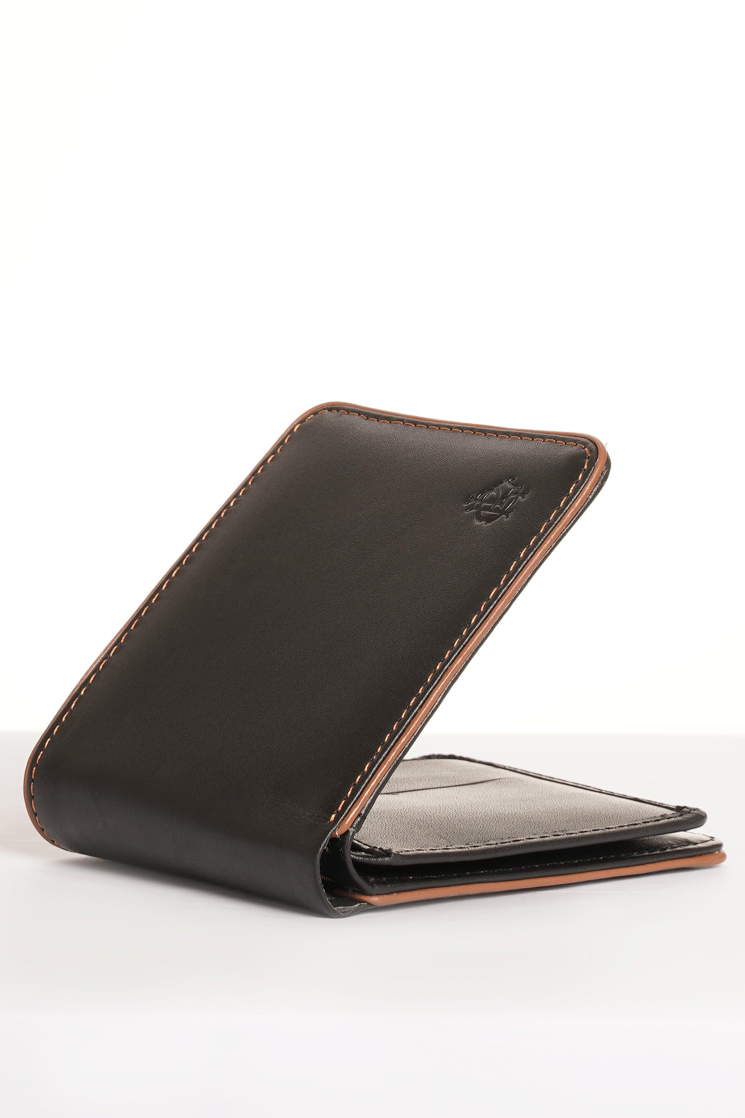 Black leather wallet with tan trim, angled view of open fold and interior