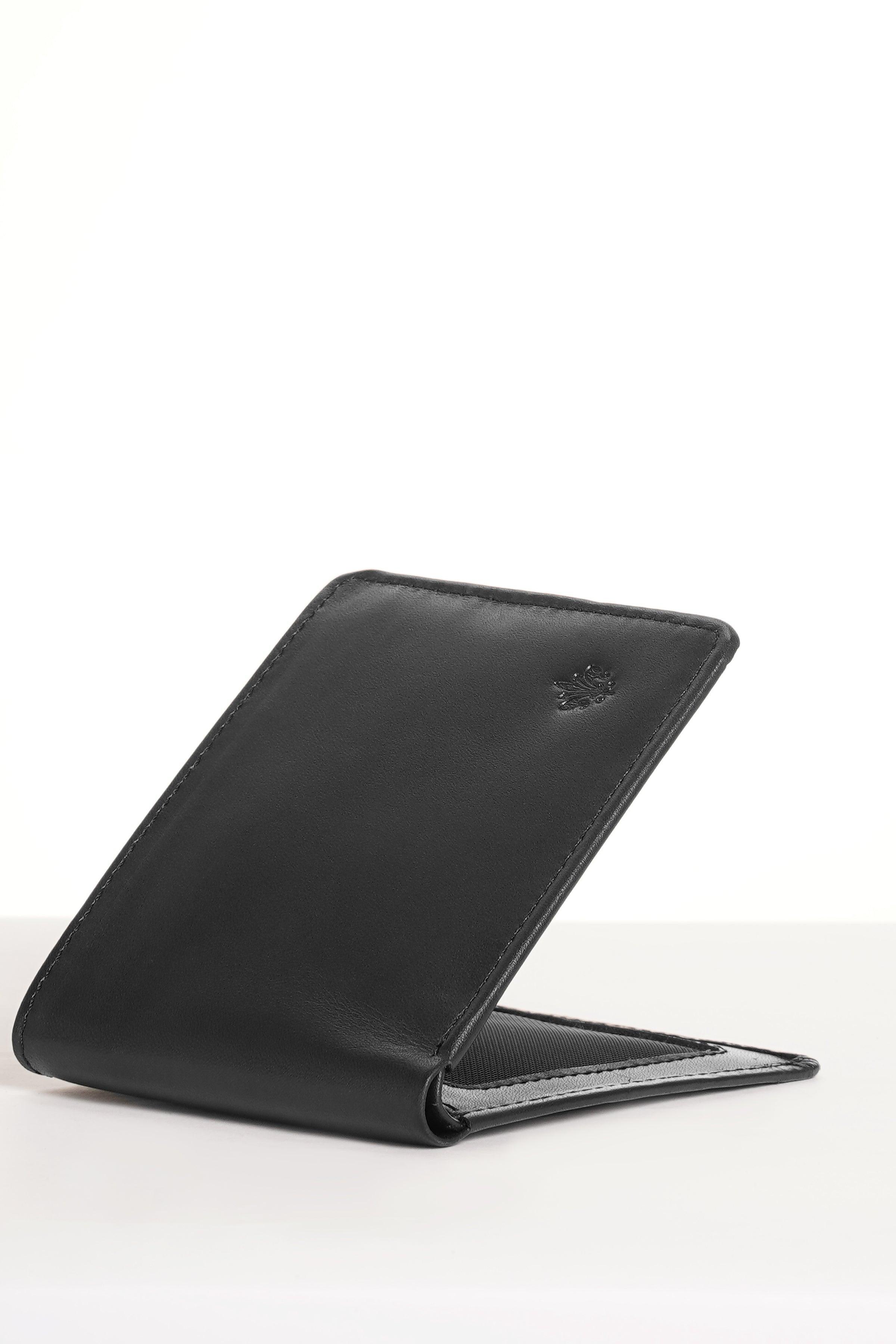 Black wallet standing at angle with slim profile and stitched edge