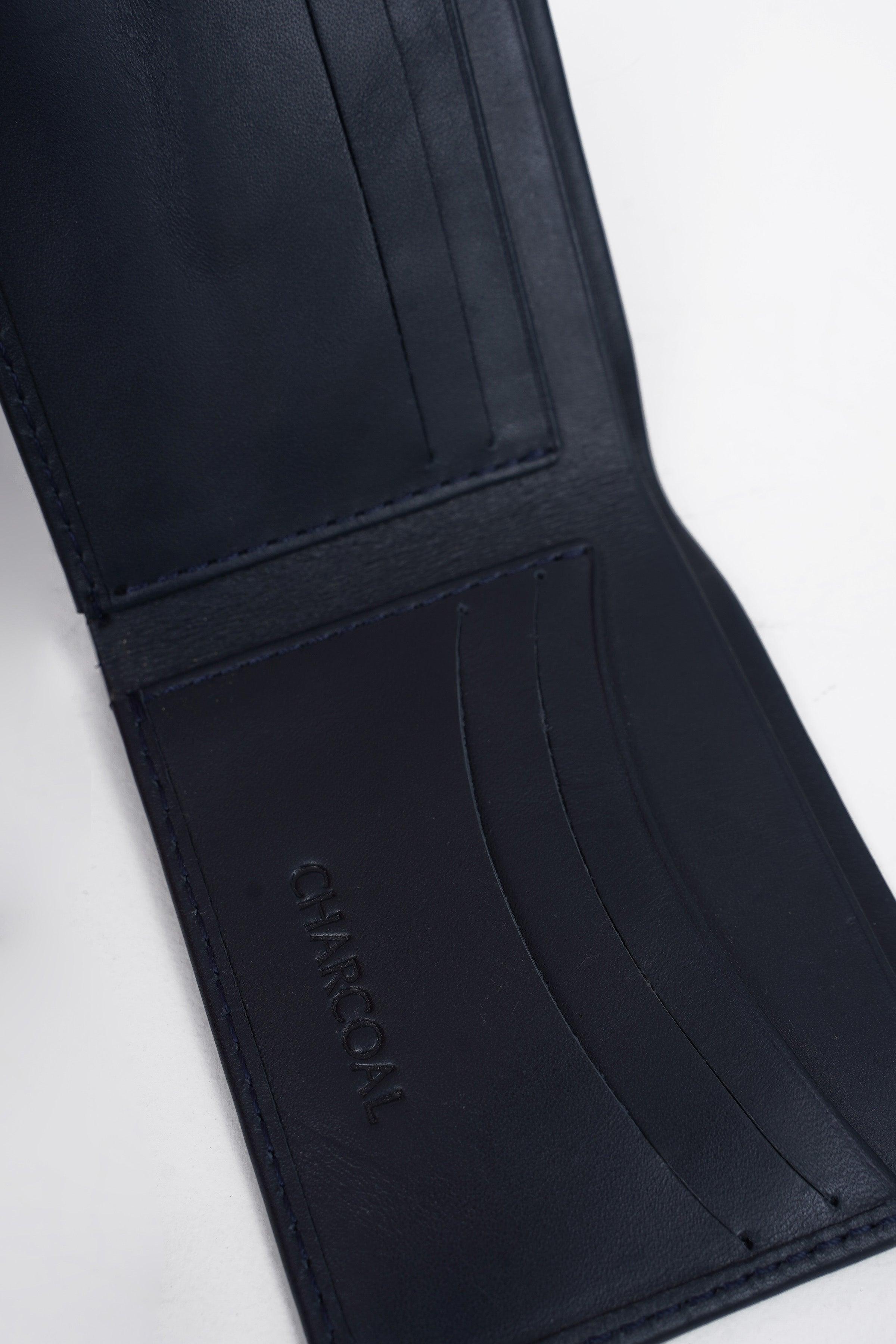 Dark blue wallet interior with card compartments and embossed brand mark
