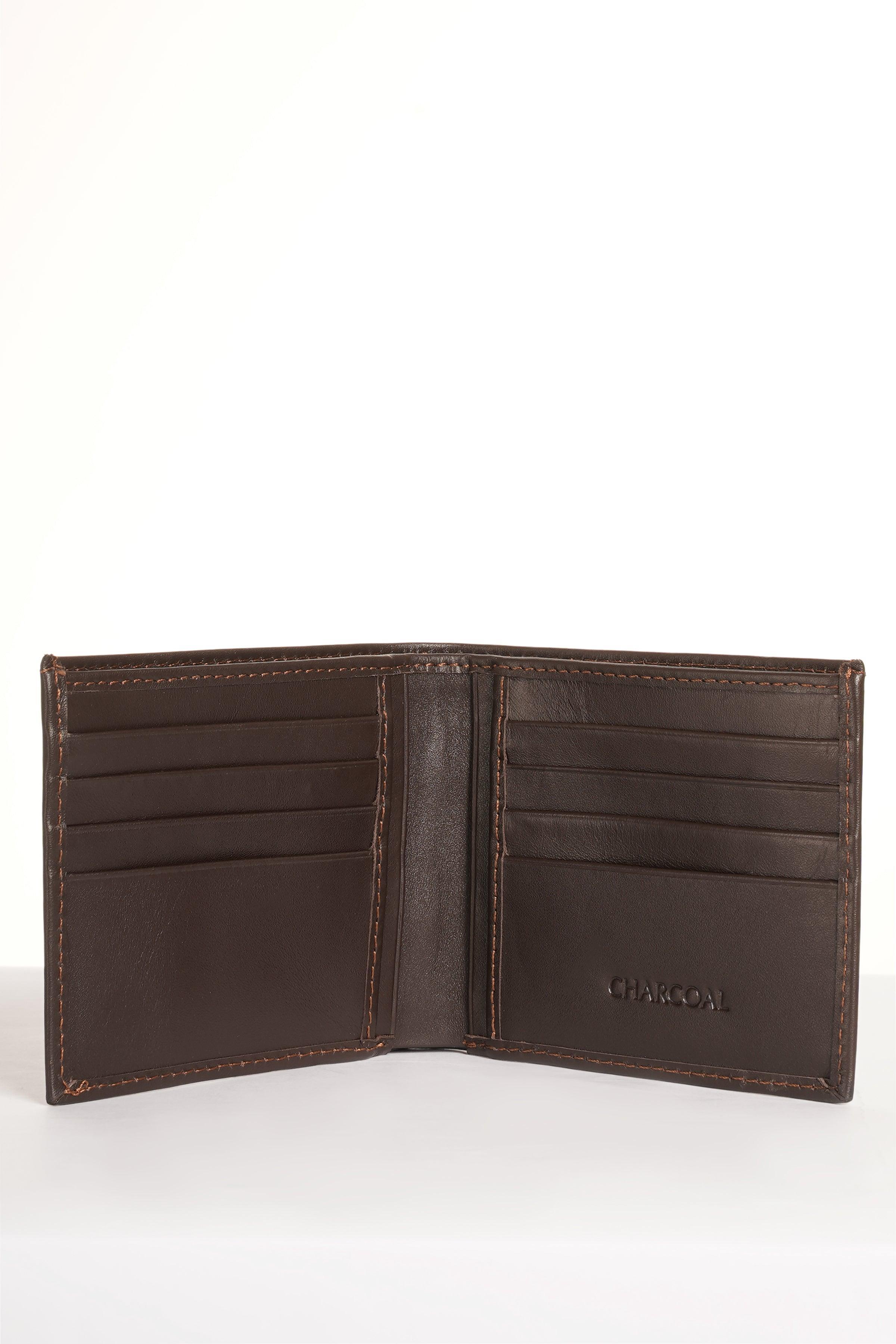 Brown leather bifold wallet opened to card slots with stitched interior panels