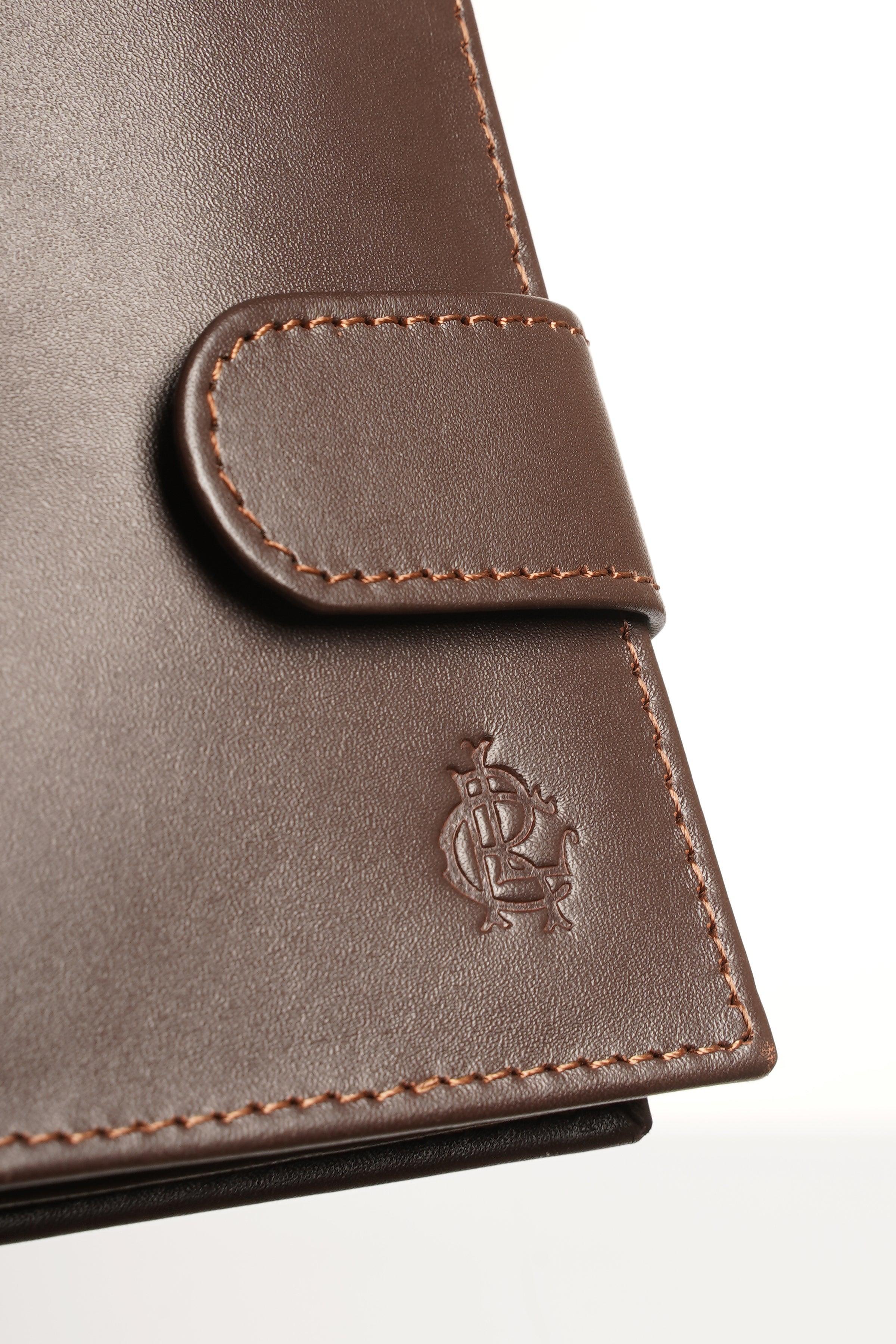 Brown leather wallet close-up with stitched tab and embossed logo