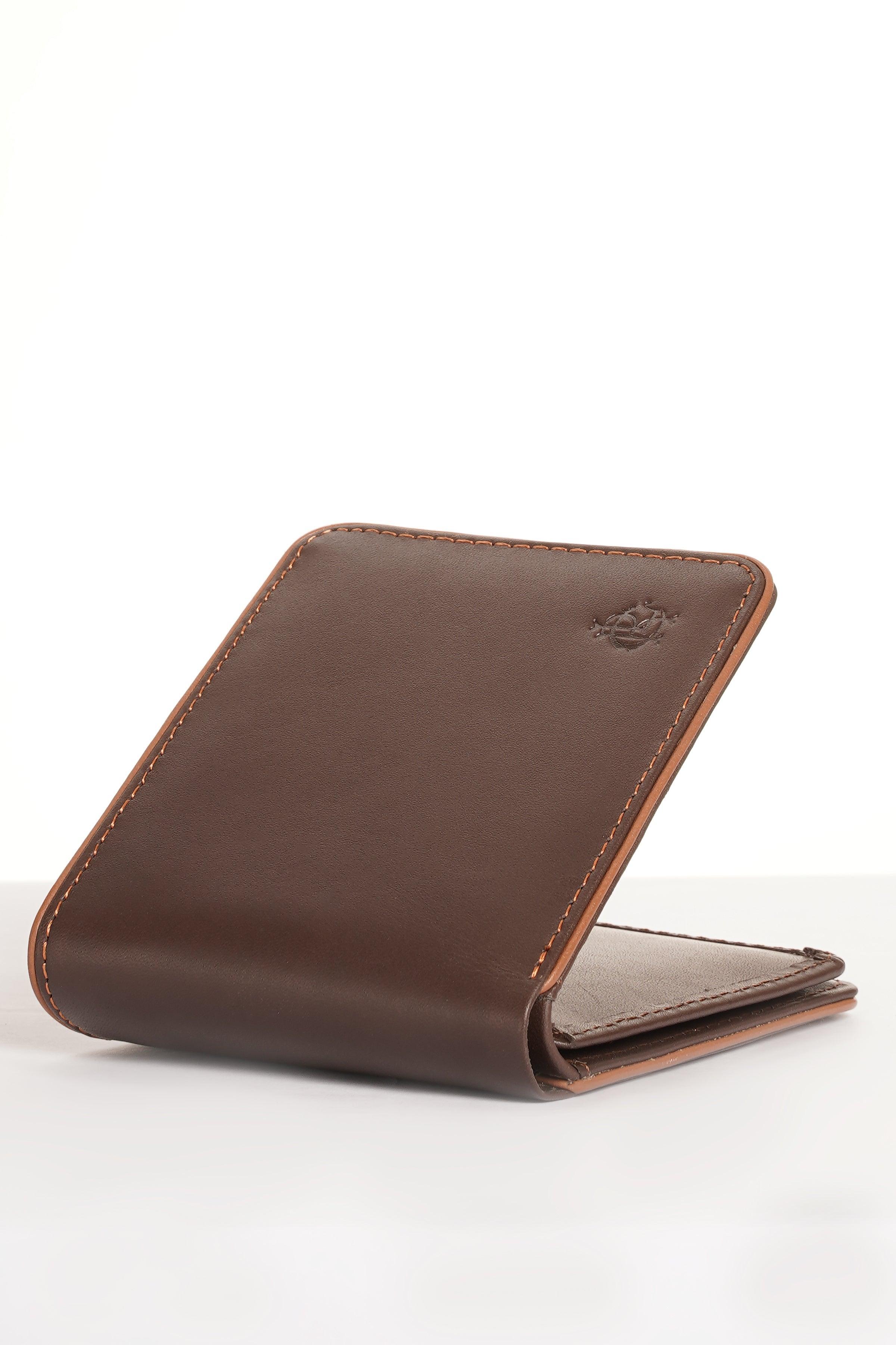 Brown leather card wallet on edge, embossed emblem