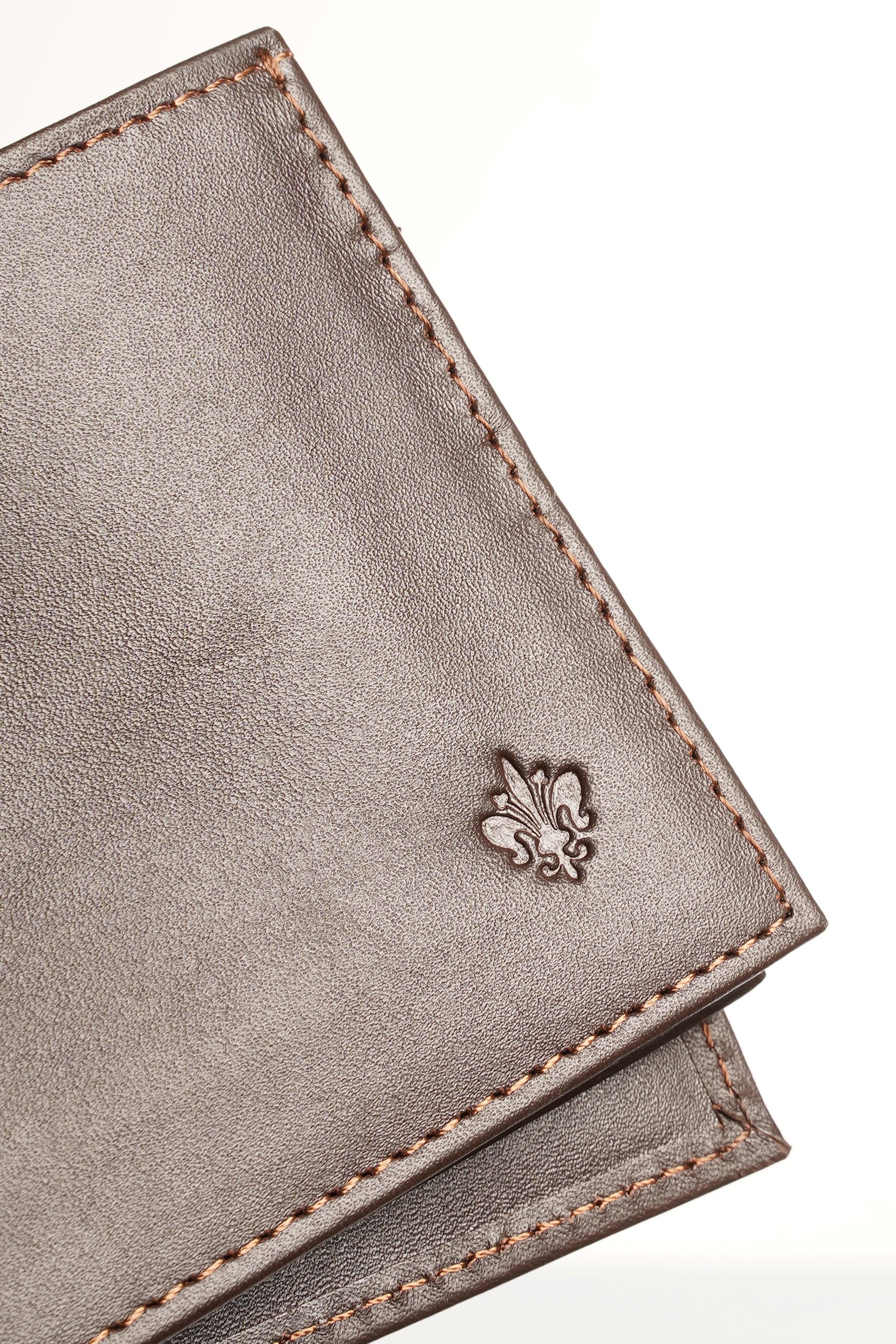 Brown leather wallet corner with embossed fleur-de-lis and contrast stitching