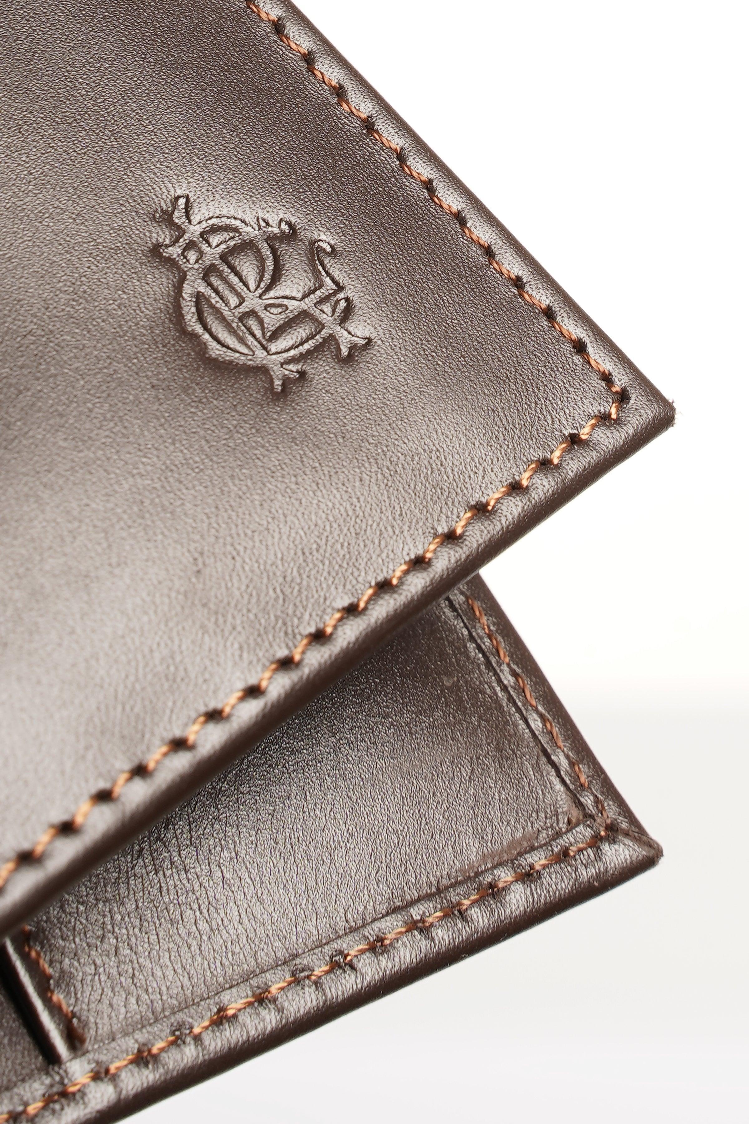 Brown leather wallet close-up with embossed logo and orange-brown stitching