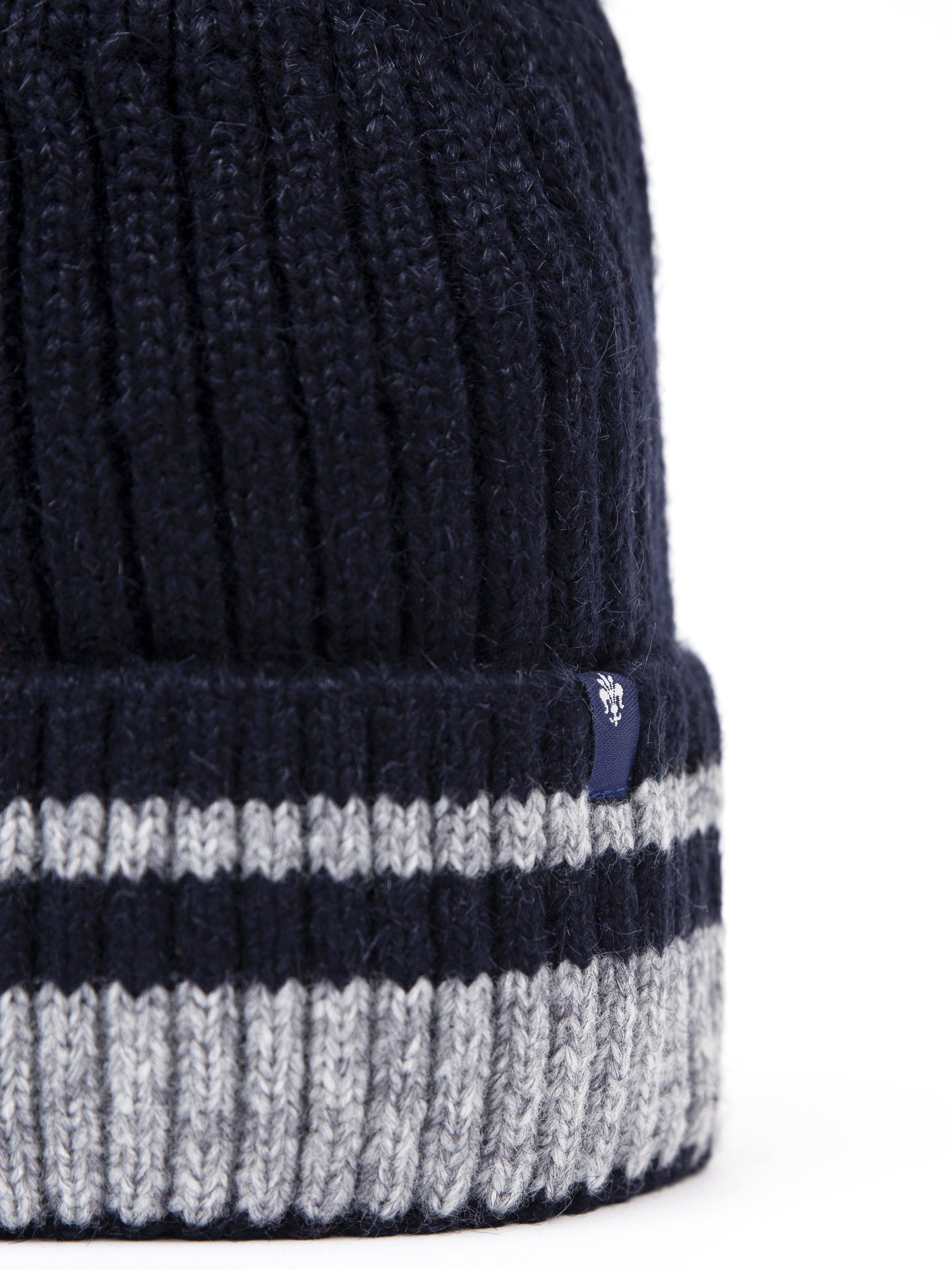Navy wool beanie cuff closeup with white-gray ribbed stripe and small logo patch