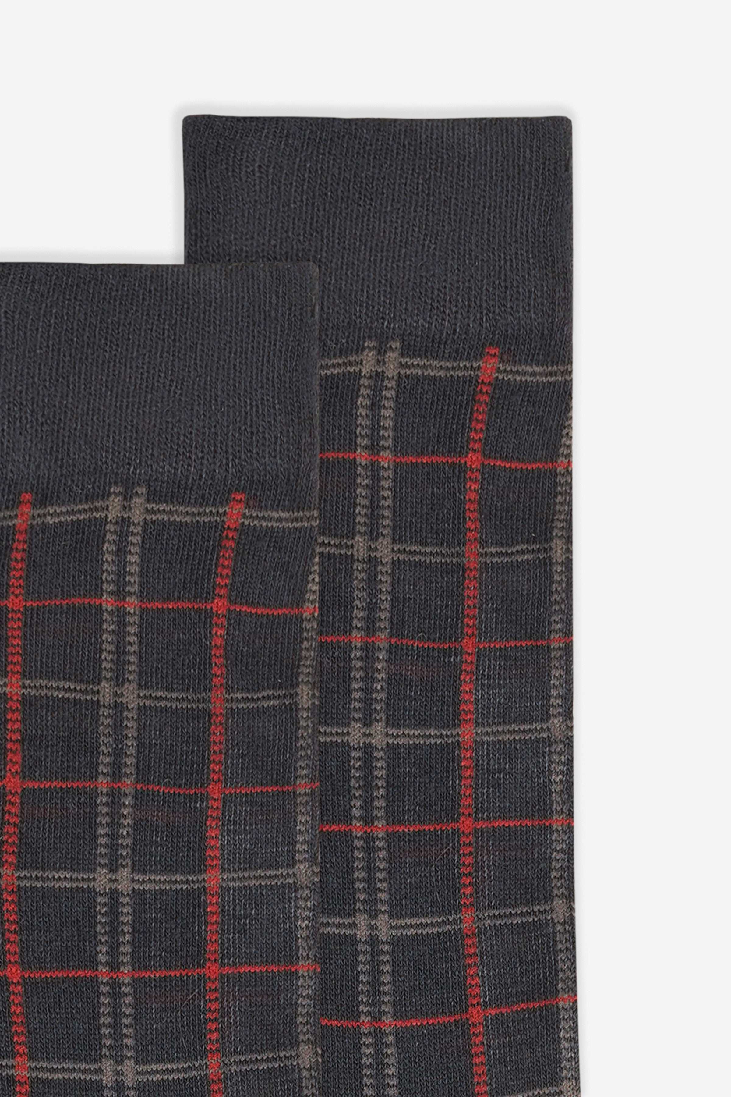 Wool sock fabric close-up with red plaid grid on dark knit