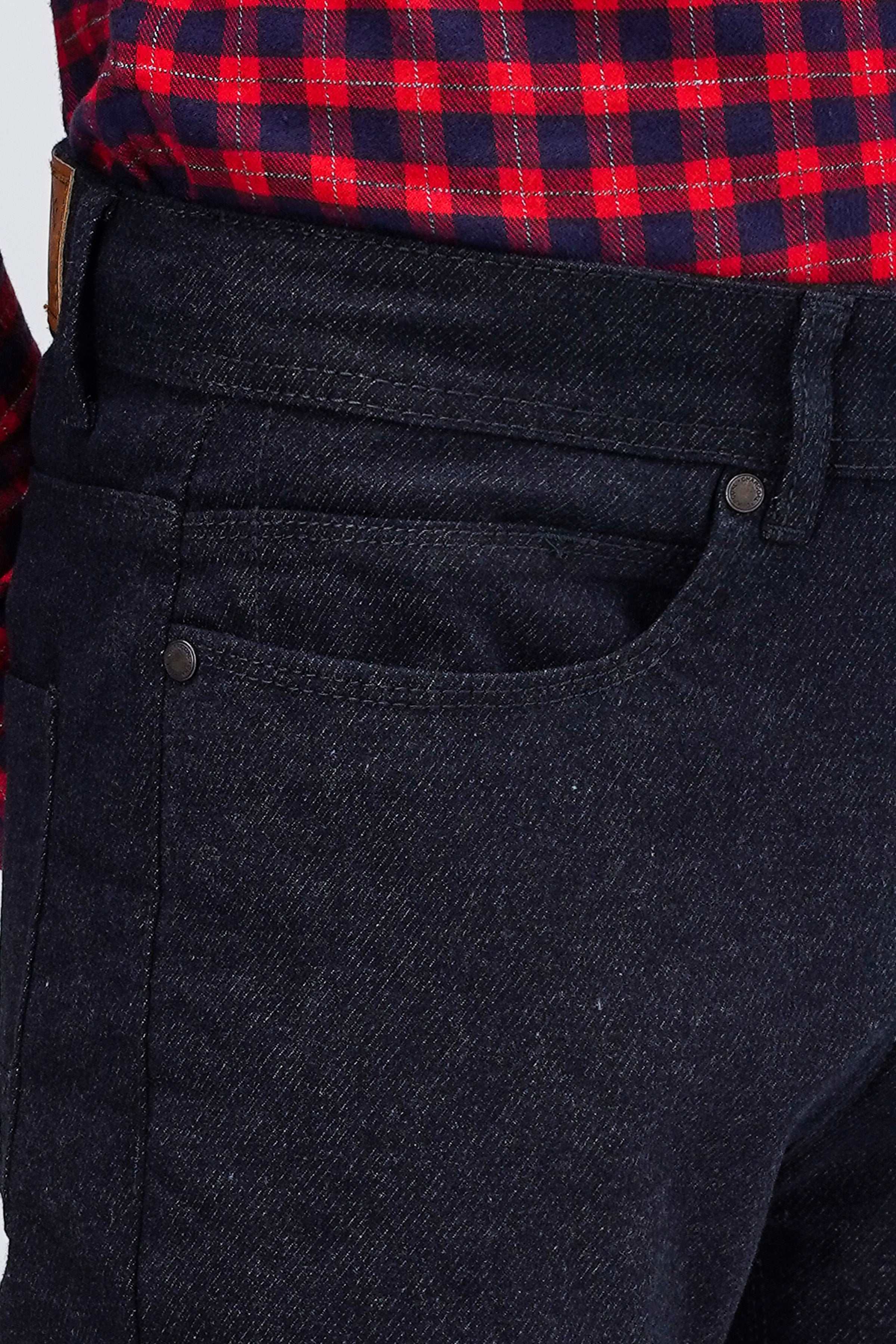 Dark denim front pocket and button detail on 5-pocket pant